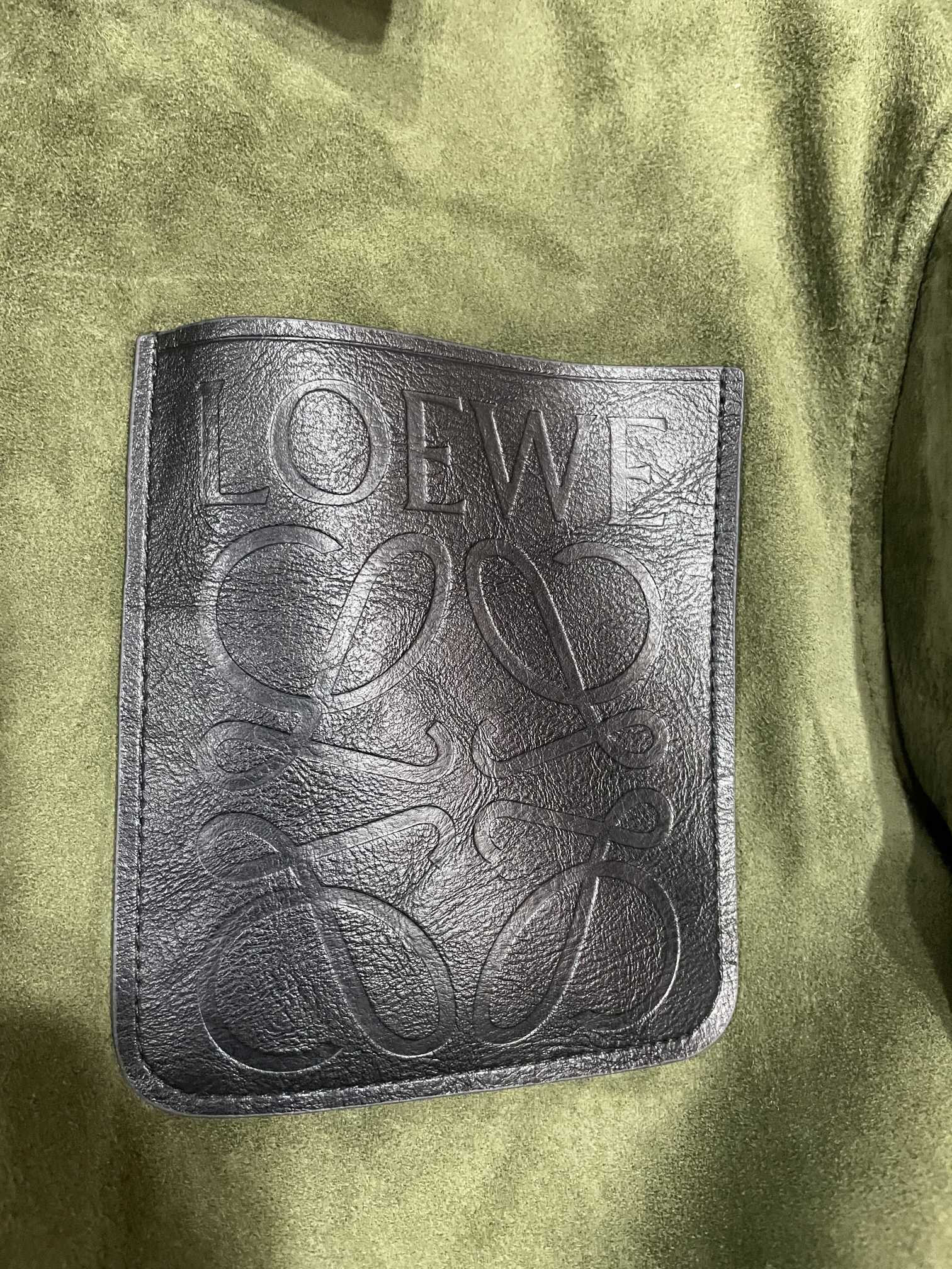 P3600 💥 LOEWE ロエベ 24 秋冬新作 メンズ スエード シープスキン レザージャケット フラットディテール💥👀このレザージャケットはオーストラリア輸入のアーミーグリーンのスエードシープスキンの質感がとにかく絶対的な息子です！👍👍ᘎ 胸元のブラック光沢レザーのLOEWEロゴエンボスポケットはユニークで、ブランドのグラマラスさを際立たせ、全体のルックを一気にレベルアップさせてくれます🥕。👔 襟、裾、袖口に施された光沢のあるブラックのシープスキンステッチは、スタイリッシュで実用的。⌚️ロエベは本当にディテールにこだわりすぎている！随所に精巧な職人技とハイエンドな品質が表れている。💖このような革のジャケットは、ファッションのシンボルであるだけでなく、生活の質の具現化である男性あなたはそれを得るために急いで何を待っている！サイズ：48-56