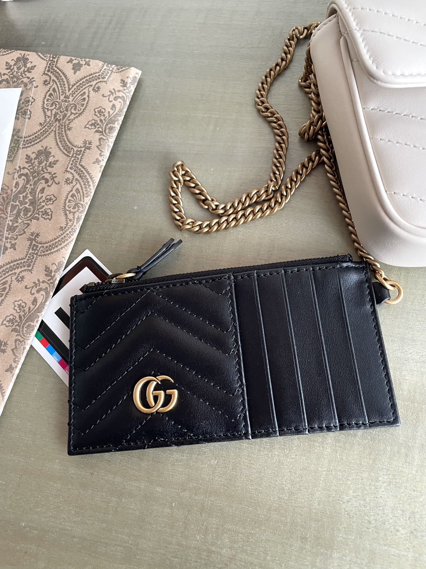 G751526 P1600 Size: 21/12/5cm! Designed with double G hardware, this mini chain card case with chain shoulder strap is crafted in signature white quilted V leather and features a removable black leather card holder.