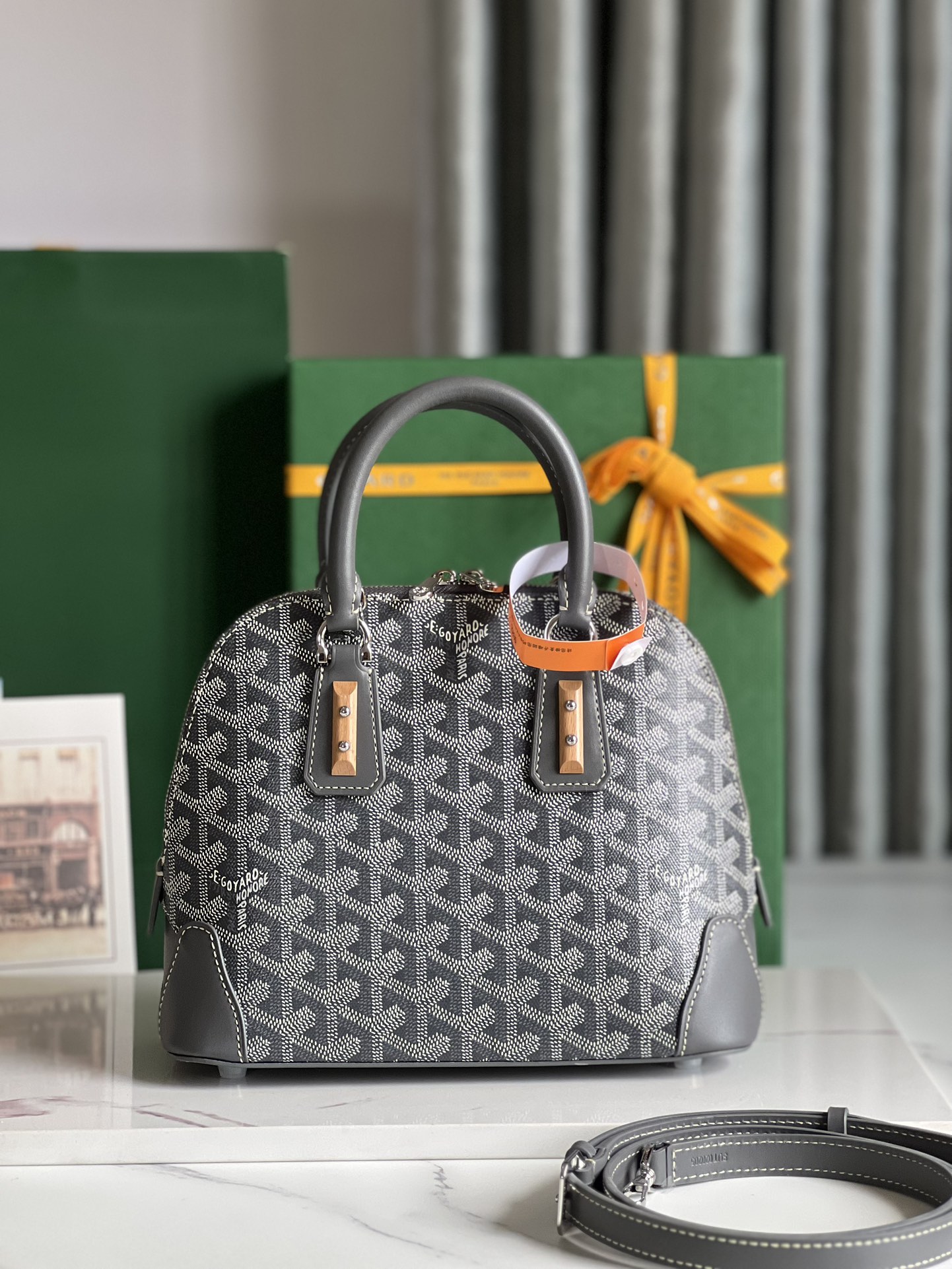 P1560 Goyard Vendôme灰色贝壳包™️
传承了品牌独一无二的工艺风格和精湛技术：可拆卸肩带、嵌入式木质细节、皮革包角、大拉链、黄色衬里及其独特的贝壳形状更具现代感和精致度展现女性柔美与轻盈的姿态🉑️肩背🉑️手拎👇🏻👇🏻
尺寸Size：底长23cm*高18.5cm*底宽10cm-高仿包包