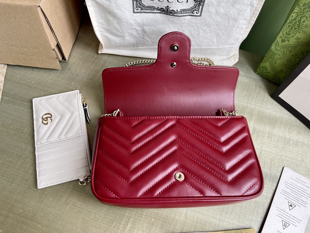 Modèle : 751526 Cora Red Taille : 21/12/5 P1600 Ce mini sac GG Marmont est confectionné dans le nouveau cuir V matelassé Gucci Rosso Ancora rouge dans des tons or clair classiques avec des accessoires de style double G pour un glamour qui attire l'attention.Gucci Rosso Ancora cuir rouge matelassé en VPorte-cartes en cuir blancQuincaillerie en or clairDoublure en tissu nuage et microfibre de daimDouble GIntérieur : deux compartiments à cartes avec porte-cartes zippé amovibleExtérieur : une poche arrièreFermeture par bouton-pression