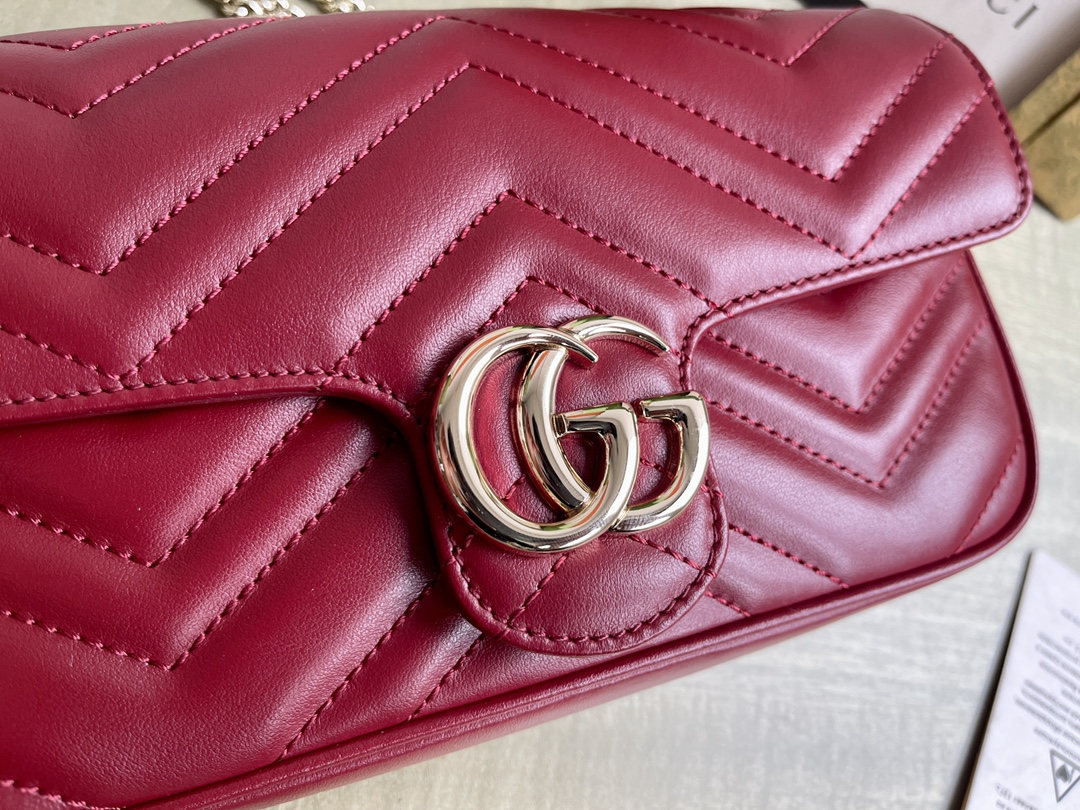 Modèle : 751526 Cora Red Taille : 21/12/5 P1600 Ce mini sac GG Marmont est confectionné dans le nouveau cuir V matelassé Gucci Rosso Ancora rouge dans des tons or clair classiques avec des accessoires de style double G pour un glamour qui attire l'attention.Gucci Rosso Ancora cuir rouge matelassé en VPorte-cartes en cuir blancQuincaillerie en or clairDoublure en tissu nuage et microfibre de daimDouble GIntérieur : deux compartiments à cartes avec porte-cartes zippé amovibleExtérieur : une poche arrièreFermeture par bouton-pression