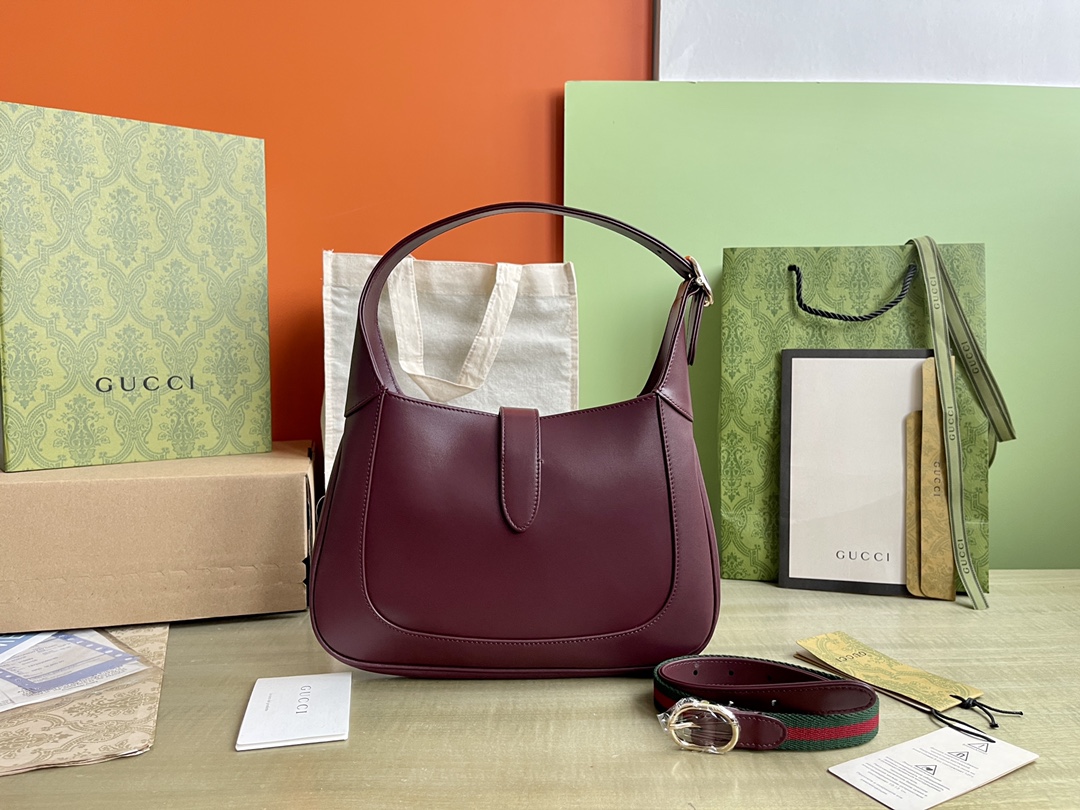 Nº de modelo: 782849 Tamaño: 27,5/19/4 P1900 Este nuevo bolso bandolera Gucci Jackie está confeccionado con las mejores pieles para mostrar la artesanía, la forma de media luna y el diseño elegante de los bolsos bandolera clásicos de la marca. La combinación de herrajes en tono dorado claro, ribetes de piel y correas complementarias con cincha roja y verde aportan más posibilidades de uso a este pequeño bolso bandolera Gucci Jackie confeccionado en la clásica piel roja Gucci Rosso Ancora de la marca. La combinación de herrajes en tono dorado claro, ribetes de piel y correas complementarias con cincha roja y verde aportan más posibilidades de uso a este pequeño bolso bandolera Gucci Jackie confeccionado en la clásica piel roja Gucci Rosso Ancora de la marcaPiel Gucci Rosso AncoraHerrajes en tono dorado claroForro de pielInterior: un bolsillo con cremallera decorado con la insignia de GucciAsas superiores con cremallera (18 cm de altura)Correa bandolera de cincha extraíble (52 cm de altura)Cierre de gancho y lazo-Fábrica de alto impacto