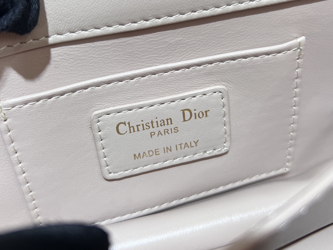 P1280 NEW DIOR ANGE HANDBAG WHITE This Dior Ange handbag is a new addition to the Fall 2014 Ready-to-Wear collection and opens Dior's new collection with an elegant and chic aesthetic crafted in white cowhide leather with oversized rattan check stitching and a stiff vintage gold-tone finish metal top handle engraved with the Christian Dior Paris logo Flap decorated with a CD clasp with resin beadwork embellishments and a sewn triangle lining. Resin-beaded CD claspSewn triangular liningThe silhouette is complemented by two spacious compartments and a slit pocket for storing everyday essentialsThe miniature style is elegantly designedAdjustable, detachable chain shoulder strap made of gold-finish metal with resin-beaded embellishmentsCD claspShoulder strap can be carried by hand, over the shoulder or across the bodyCode: 4401Measurements: 20 x 12 x 5 cm (L x H x W)Length of shoulder strap: 53 cm - 5.5 cm (L x W) High-quality imitation factory