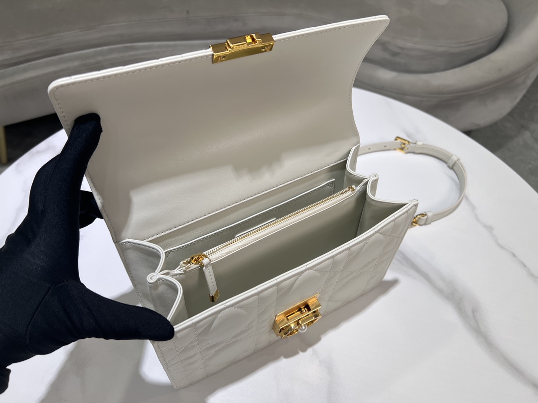 Grande P1400El bolso Dior Ange, novedad de la colección prêt-à-porter otoño 2014, inaugura la nueva colección de Dior con una estética elegante y chic elaborada en piel color crema con pespuntes de cuadros de ratán sobredimensionados y asas superiores rígidas de metal dorado vintage grabadas con el logo Christian Dior ParisSolapa decorada con un cierre CD embellecido con abalorios de resinaCosido. Silueta triangular forrada con dos amplios compartimentos y un bolsillo portaobjetos para guardar los objetos de uso diarioCorrea bandolera de cadena ajustable y desmontable de metal dorado con adornos de abalorios de resinaPuede llevarse en la mano, colgado del hombro o cruzadoCódigo: 4402Medidas: 25x 16x 8 cm (L x A x A)-High-Fashion Factory