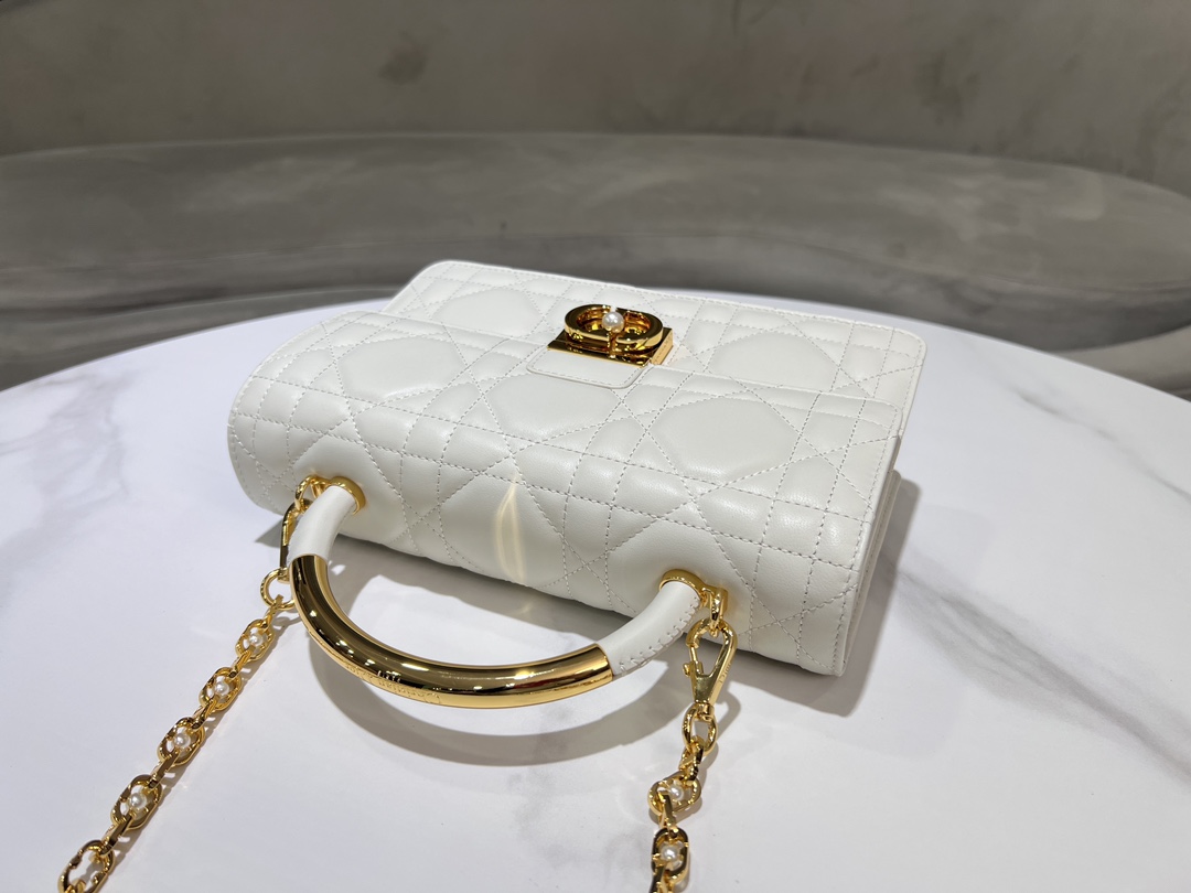 Large P1400Le sac Dior Ange, nouveau dans la collection Prêt-à-porter Automne 2014, ouvre la nouvelle collection de Dior avec une esthétique élégamment chic réalisée en cuir crème avec des surpiqûres à carreaux de rotin surdimensionnées et des anses supérieures raidies en métal doré vintage gravées du logo Christian Dior ParisPatte décorée d'un fermoir CD rehaussé de perles de résineCousu en. Silhouette triangulaire doublée avec deux compartiments spacieux et une pochette fendue pour ranger les essentiels de tous les joursStyle moyen élégantSangle d'épaule réglable et amovible en métal doré avec perles de résineAnneau en chaîne CDPeut être porté comme un sac à main, à l'épaule ou en bandoulièreCode : 4402Dimensions : 25x 16x 8 cm (L x H x l)-Sacs de haute qualité