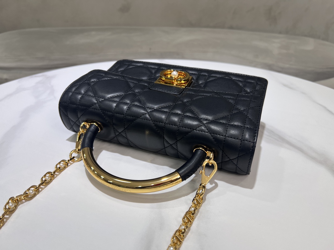 Grand P1400Le sac Dior Ange, inédit dans la collection de prêt-à-porter automne 2014, ouvre la nouvelle collection de Dior avec une esthétique élégamment chic réalisée en cuir noir avec des surpiqûres à carreaux de rotin surdimensionnées et des anses supérieures raidies en métal doré vintage gravées du logo Christian Dior ParisPatte décorée d'un fermoir CD rehaussé de perles de résineCousu en. Silhouette triangulaire doublée avec deux compartiments spacieux et une poche fendue pour ranger vos essentiels quotidiensStyle moyen élégantSangle d'épaule en chaîne réglable et amovible en métal doré avec perles de résineCode : 4402Mesures : 25x 16x 8 cm (L x H x l)-Sacs de haute qualité