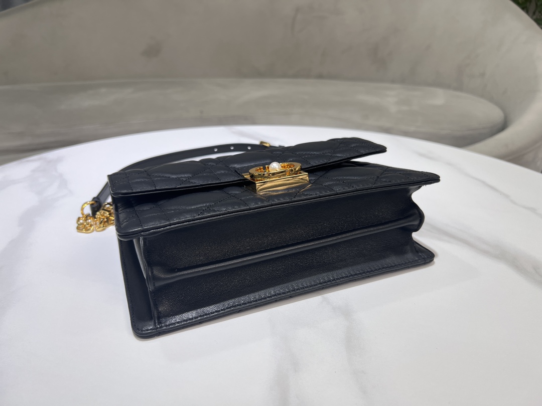 Grand P1400Le sac Dior Ange, inédit dans la collection de prêt-à-porter automne 2014, ouvre la nouvelle collection de Dior avec une esthétique élégamment chic réalisée en cuir noir avec des surpiqûres à carreaux de rotin surdimensionnées et des anses supérieures raidies en métal doré vintage gravées du logo Christian Dior ParisPatte décorée d'un fermoir CD rehaussé de perles de résineCousu en. Silhouette triangulaire doublée avec deux compartiments spacieux et une poche fendue pour ranger vos essentiels quotidiensStyle moyen élégantSangle d'épaule en chaîne réglable et amovible en métal doré avec perles de résineCode : 4402Mesures : 25x 16x 8 cm (L x H x l)-Sacs de haute qualité