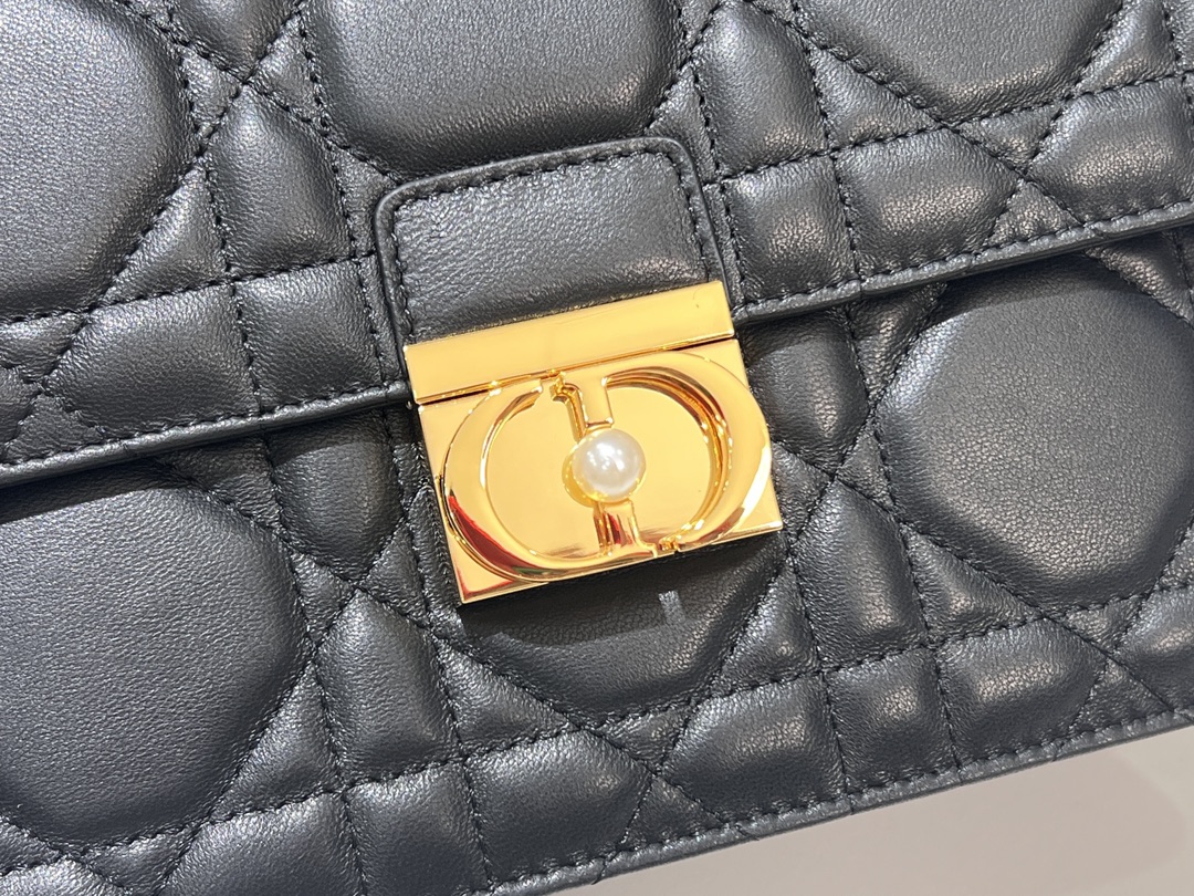 Grand P1400Le sac Dior Ange, inédit dans la collection de prêt-à-porter automne 2014, ouvre la nouvelle collection de Dior avec une esthétique élégamment chic réalisée en cuir noir avec des surpiqûres à carreaux de rotin surdimensionnées et des anses supérieures raidies en métal doré vintage gravées du logo Christian Dior ParisPatte décorée d'un fermoir CD rehaussé de perles de résineCousu en. Silhouette triangulaire doublée avec deux compartiments spacieux et une poche fendue pour ranger vos essentiels quotidiensStyle moyen élégantSangle d'épaule en chaîne réglable et amovible en métal doré avec perles de résineCode : 4402Mesures : 25x 16x 8 cm (L x H x l)-Sacs de haute qualité