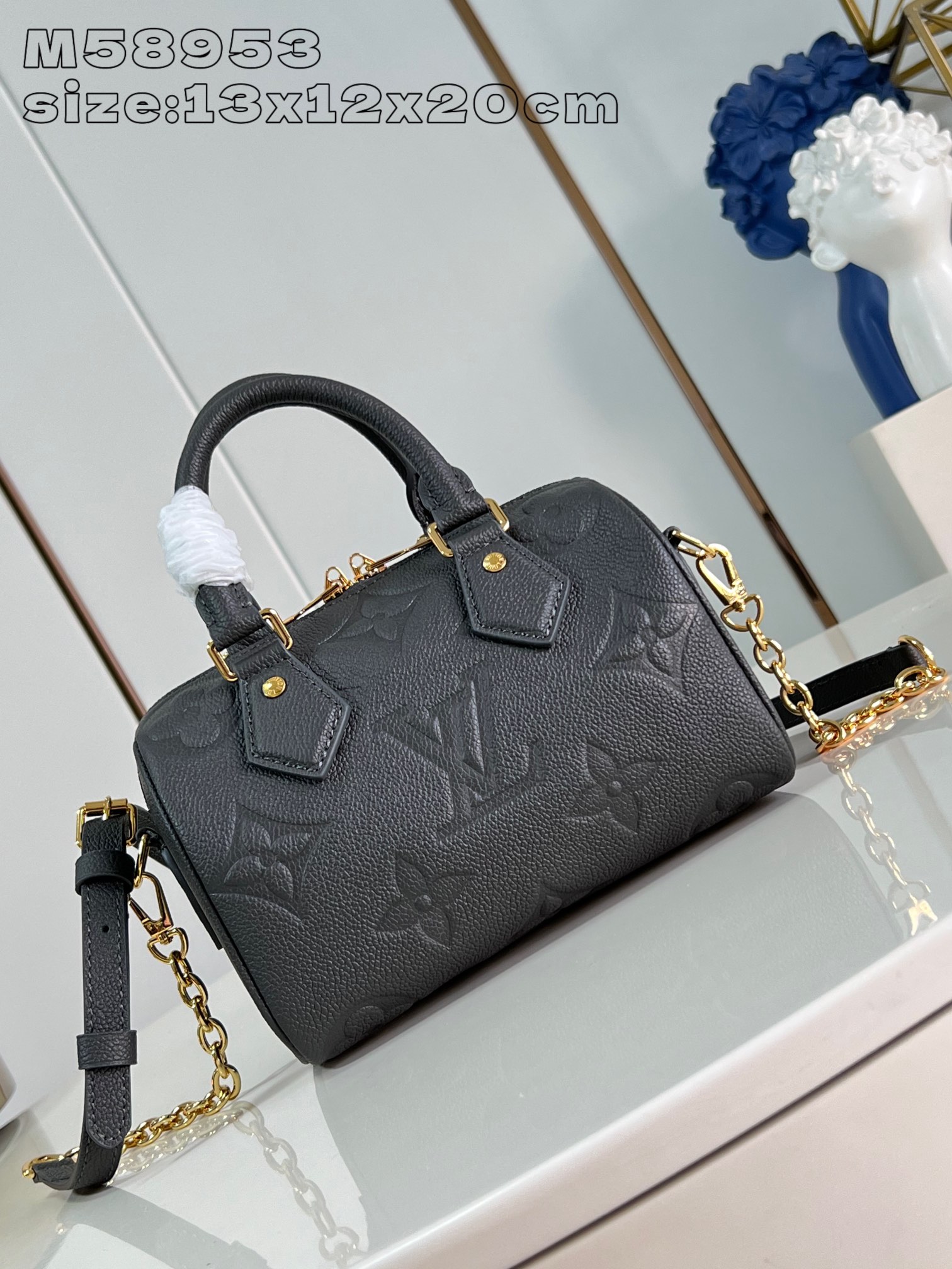 M58953 Gunmetal The Speedy Bandoulière 20 is a smart and stylish way to carry your daily needs in smooth Monogram Empreinte grained leather with large Monogram embossing, a padlock, metal hardware, a detachable and adjustable chain shoulder strap and Toron handles 13.5 x 12 x 20 cm (H x W x D). 20.5 cm (H x W x L)