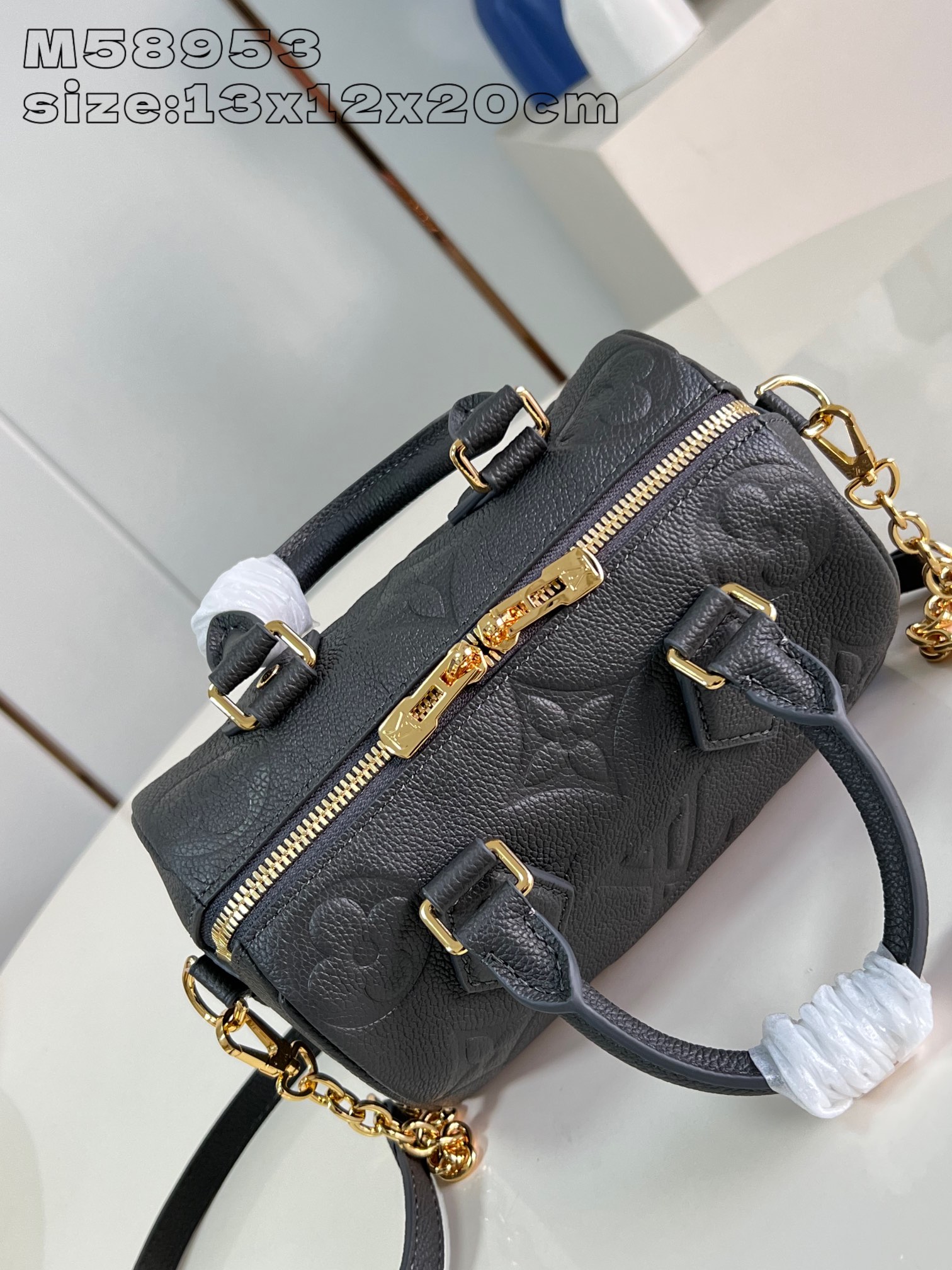 M58953 Gunmetal The Speedy Bandoulière 20 is a smart and stylish way to carry your daily needs in smooth Monogram Empreinte grained leather with large Monogram embossing, a padlock, metal hardware, a detachable and adjustable chain shoulder strap and Toron handles 13.5 x 12 x 20 cm (H x W x D). 20.5 cm (H x W x L)