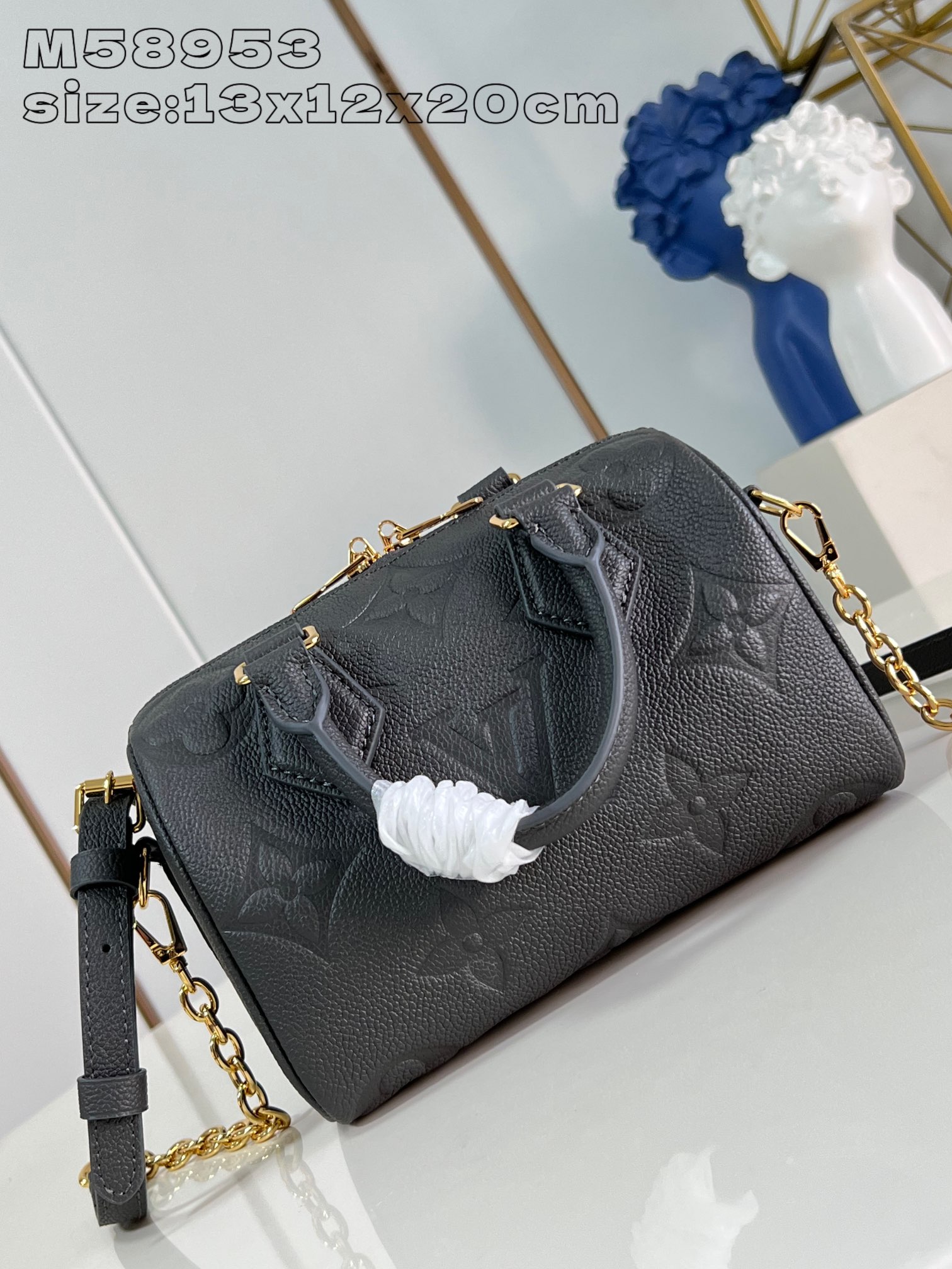 M58953 Gunmetal The Speedy Bandoulière 20 is a smart and stylish way to carry your daily needs in smooth Monogram Empreinte grained leather with large Monogram embossing, a padlock, metal hardware, a detachable and adjustable chain shoulder strap and Toron handles 13.5 x 12 x 20 cm (H x W x D). 20.5 cm (H x W x L)