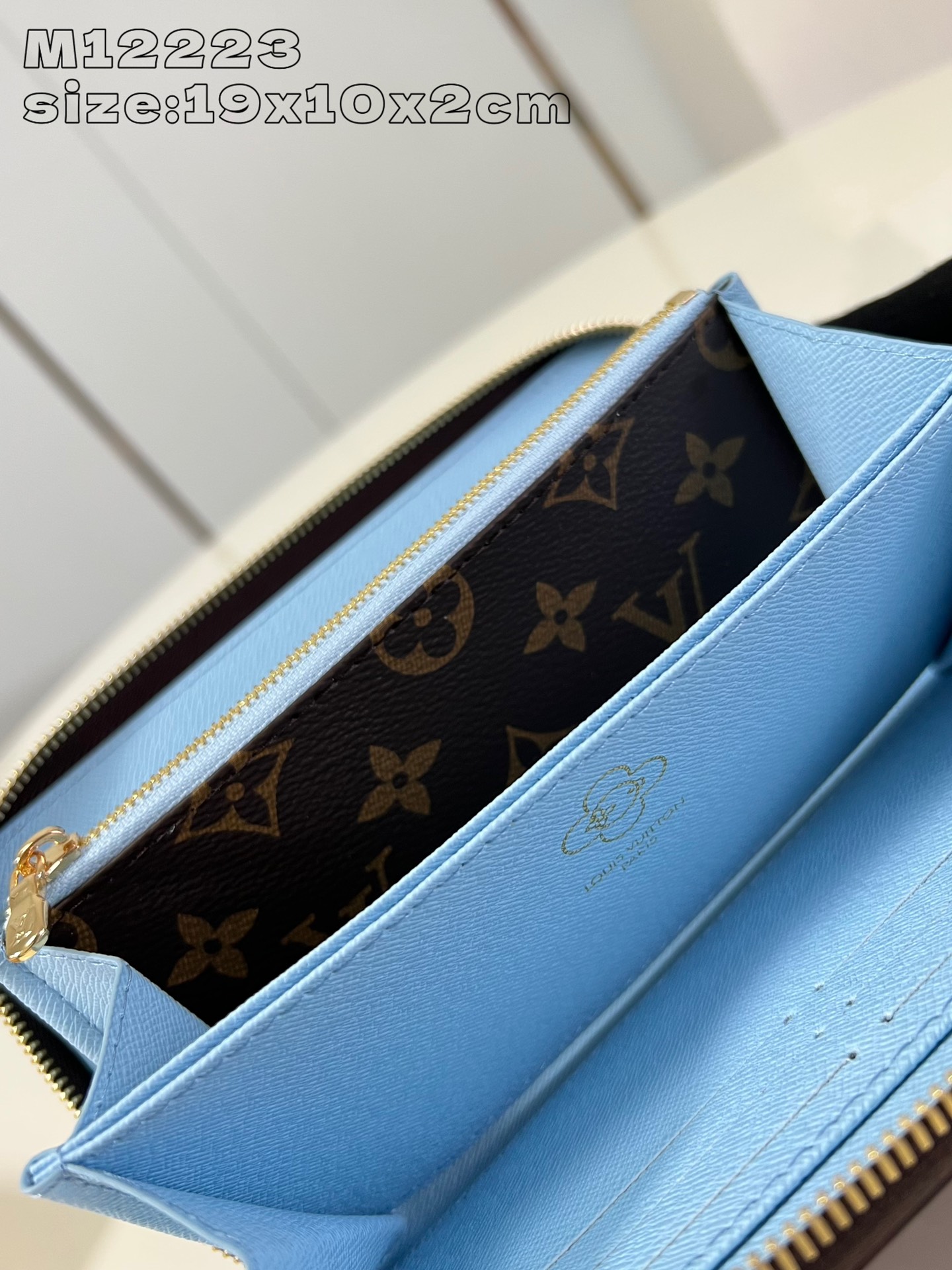 M12223 This festive zippy wallet from the Snow Show collection features Louis Vuitton's Vivienne mascot skiing in the LV snowflakes. Crafted in the iconic Monogram canvas and lined in Azur Frost leather, this playful design comes with multiple interior pockets, three compartments, and twelve business card slots 19.5 x 10.5 cm (L x H x W). x 2.5 cm (L x H x W)