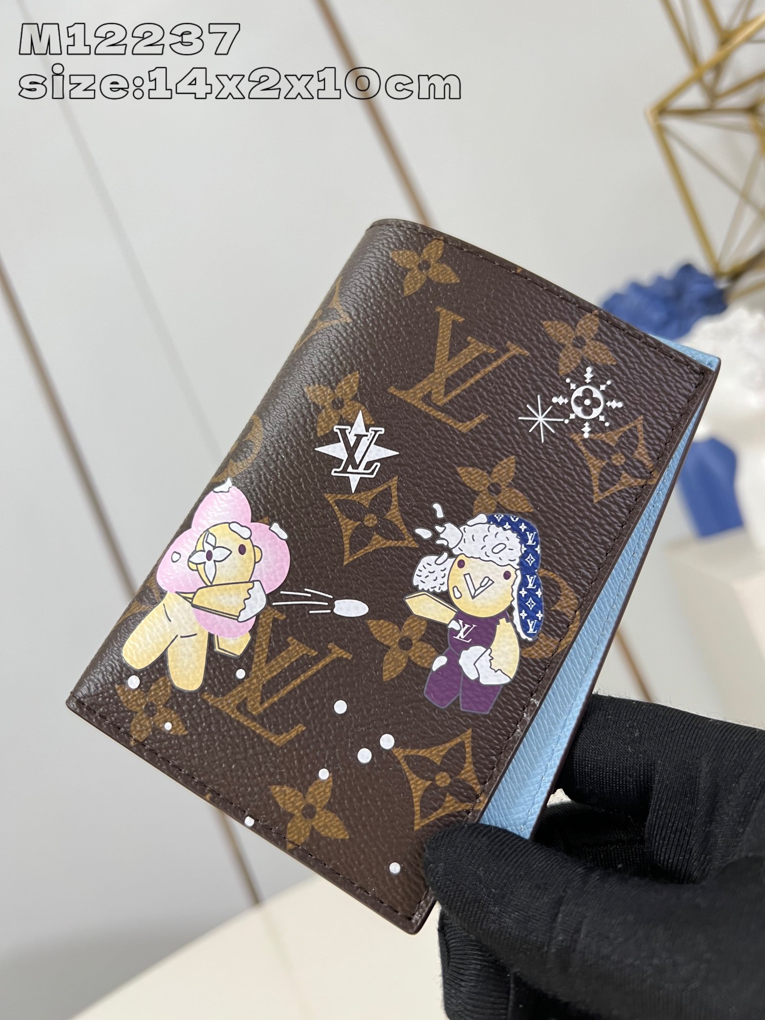 M12237 This passport holder features the brand's mascot Vivienne showcasing the Snow Show collection in Monogram canvas depicting LV snowflakes and a cuddly polar bear leather lining with eye-catching details Flap pockets and card slots for organized storage 14 x 2.5 x 10 cm (H x W x L)