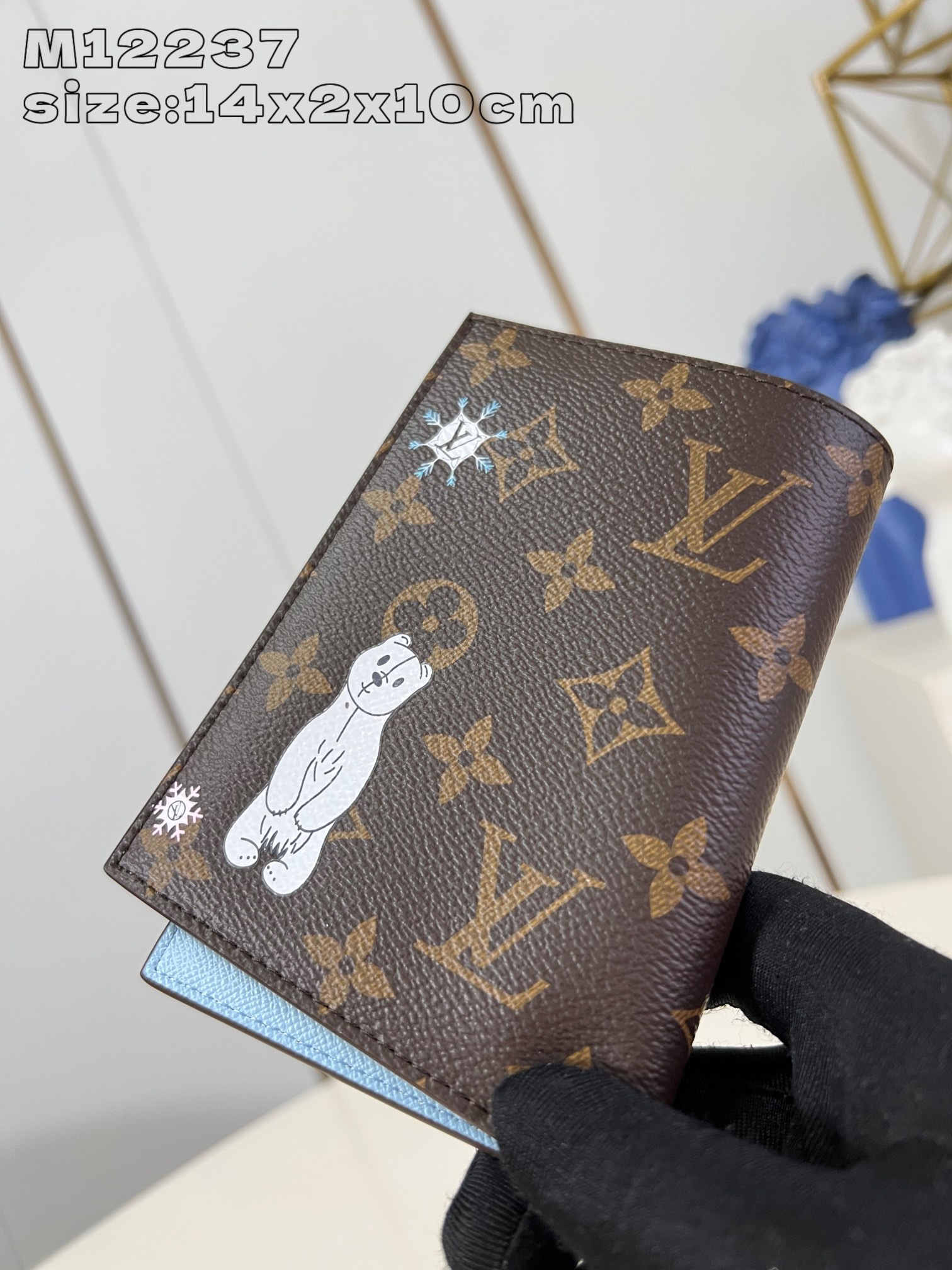 M12237 Ce porte-passeport est orné de la mascotte de la marque, Vivienne, et présente la collection Snow Show en toile Monogram représentant des flocons de neige LV et un ours polaire câlin. Doublure en cuir avec détails accentués. Poches à rabat et fentes pour cartes pour un rangement organisé 14 x 2,5 x 10 cm (H x L x P)