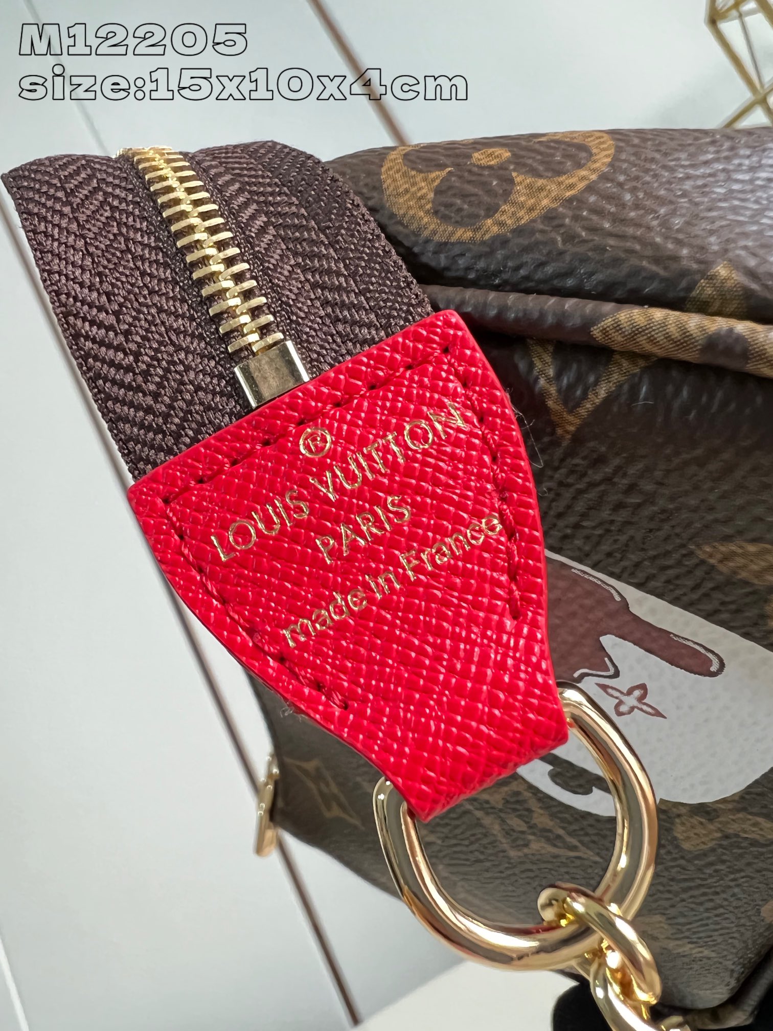 M12205 Esta festiva Mini Pochette Accessoires de la colección Candy Factory está adornada con simpáticos motivos como la icónica muñeca Vivienne dándose un baño en una jarra caliente, y está confeccionada en la emblemática lona Monogram de Louis Vuitton. Está decorada con un forro Candy rojo brillante y acabada con una cadena dorada de cierre autoadherente y una cremallera con forma de Vivienne. Diseño con cremallera en forma de Vivienne 15,5 x 10,5 x 4 cm (largo x alto x ancho)