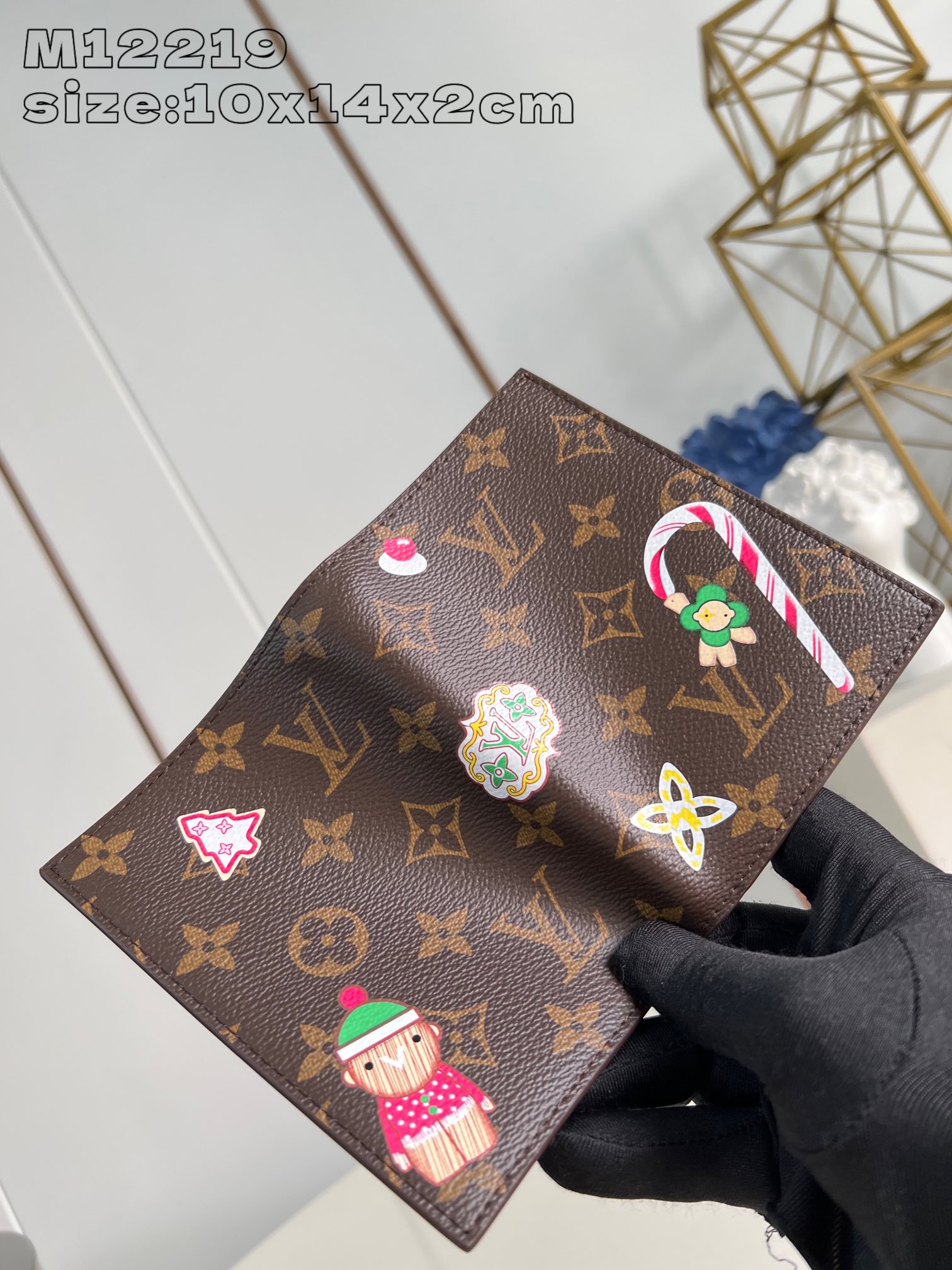 M12219 This passport cover from the Candy Factory collection features the brand's iconic mascot, Vivienne, in the iconic Monogram canvas, surrounded by festive illustrations of the classic character, including candy canes and Christmas cookies. Keeps your travel essentials organized10 x 14 x 2.5 cm (L x H x W)