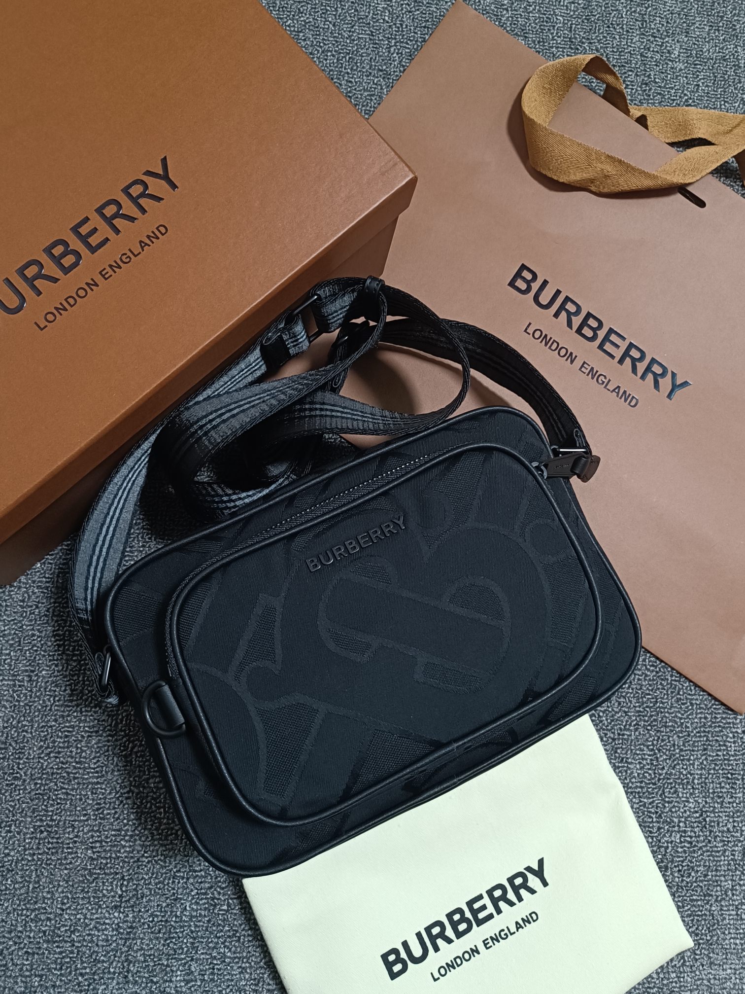 Black Burberry camera bag Crafted from recycled polyester and cotton yarns and decorated with Thomas Bur's exclusive logo patterned jacquard with the brand's logoCan be worn diagonally or with the adjustable signature striped mesh nylon strapCarrying dimensions:21.5 - 7 - 15.5cm- high quality bags