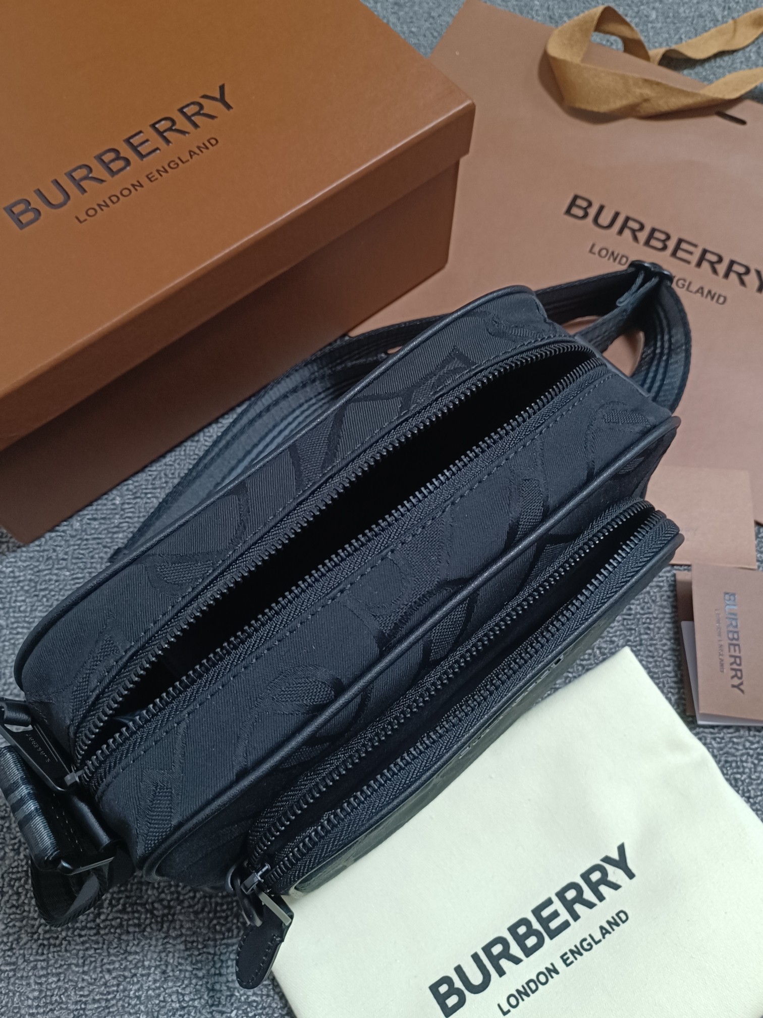 Black Burberry camera bag Crafted from recycled polyester and cotton yarns and decorated with Thomas Bur's exclusive logo patterned jacquard with the brand's logoCan be worn diagonally or with the adjustable signature striped mesh nylon strapCarrying dimensions:21.5 - 7 - 15.5cm- high quality bags