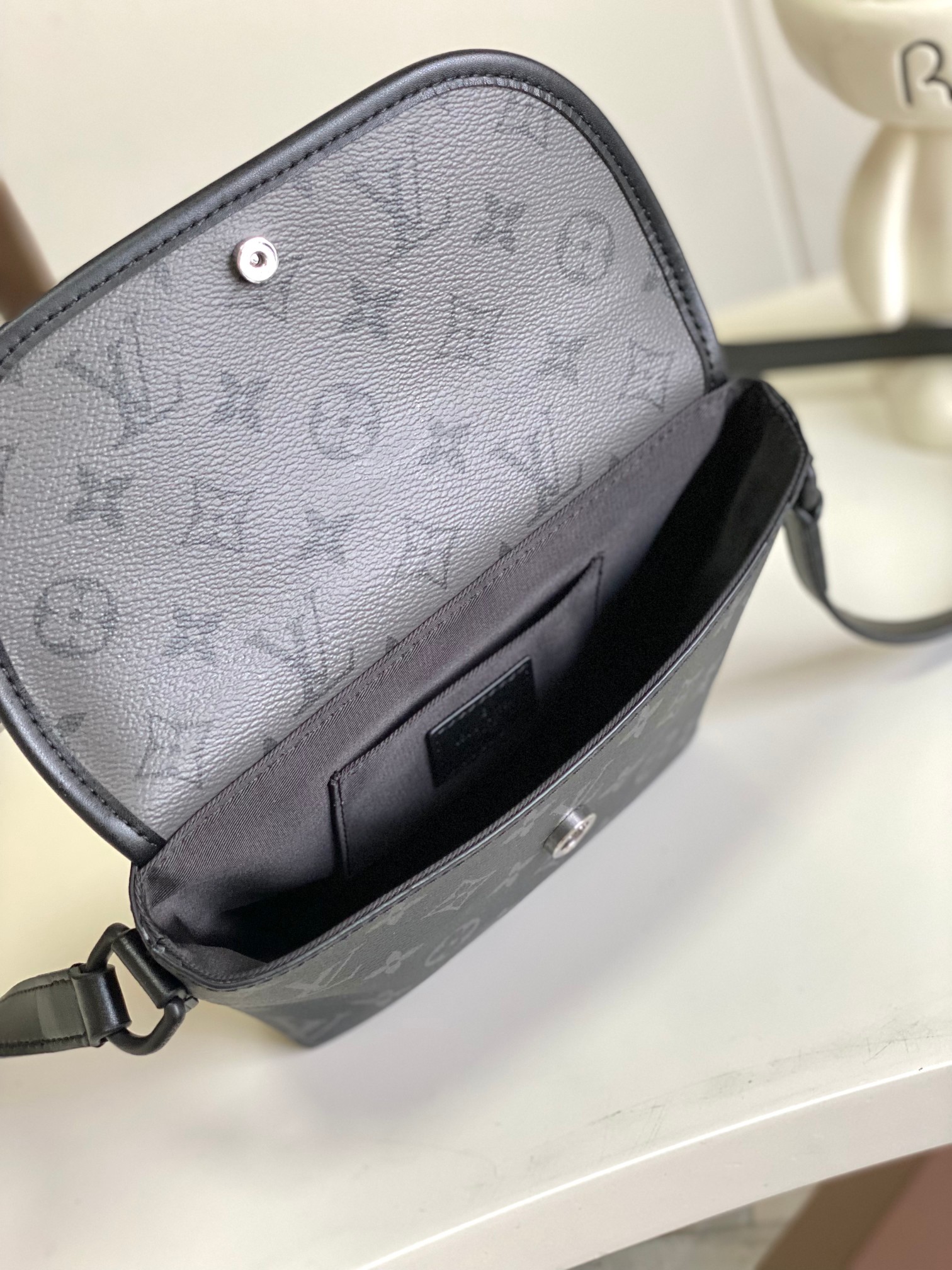 P920 Variable Chip M12806 Black/Silver Flower Small Ce mini sac Pulse est fabriqué en toile enduite Monogram Eclipse et présente des lignes épurées et des éléments sportifs pour véhiculer un look moderne dans une forme compacte avec un compartiment principal et une poche zippée sur le rabat agrémenté d'un cordon de fermeture zippée16 x 5 x 22,5 cm (H x L x P)