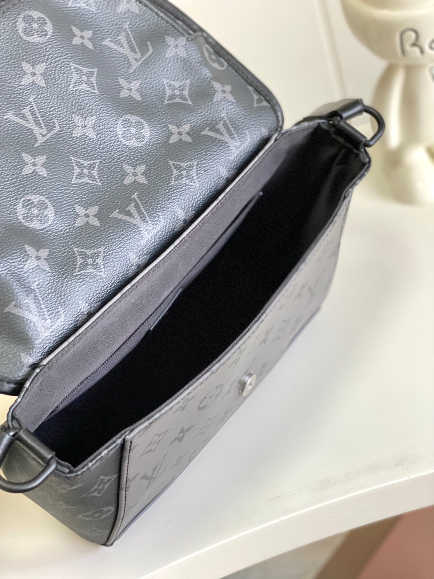 P960 Chip M12681 Black/Silver Flower Men's Bag Messenger Bag Series Le sac messager Pulse est en toile Monogram Eclipse et comporte une poche à rabat avec une fermeture à glissière et une fermeture magnétique pour un accès facile à vos effets personnels, ainsi qu'une bandoulière en cuir réglable avec des passants latéraux pour un portage à l'épaule ou en bandoulière. 17 x 11 x 26,6 cm (H x L x L)