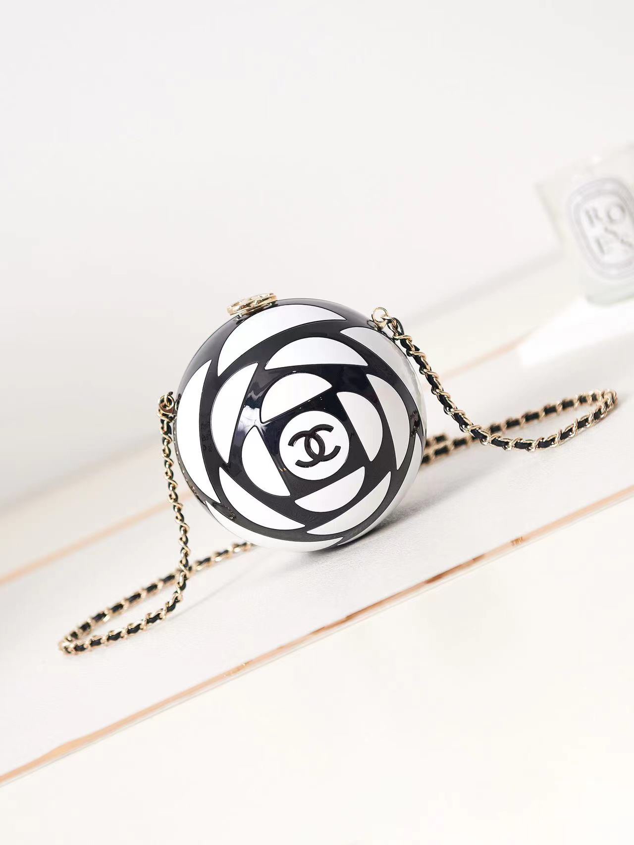 CHANEL 2023K Camellia Agora, na Semana da Moda primavera/verão, foi lançada uma mala de noite em forma de bola O seu esquema de cores preto e branco é quase igual ao da bola de futebol Saco de noite rígido em forma de bola Esmalte de resina e pele dourada através da corrente Construção pesada em preto metálico e branco metálico Versão oposta do modelo número AS3716 Tamanho 12-12-12-Fábrica de alta costura