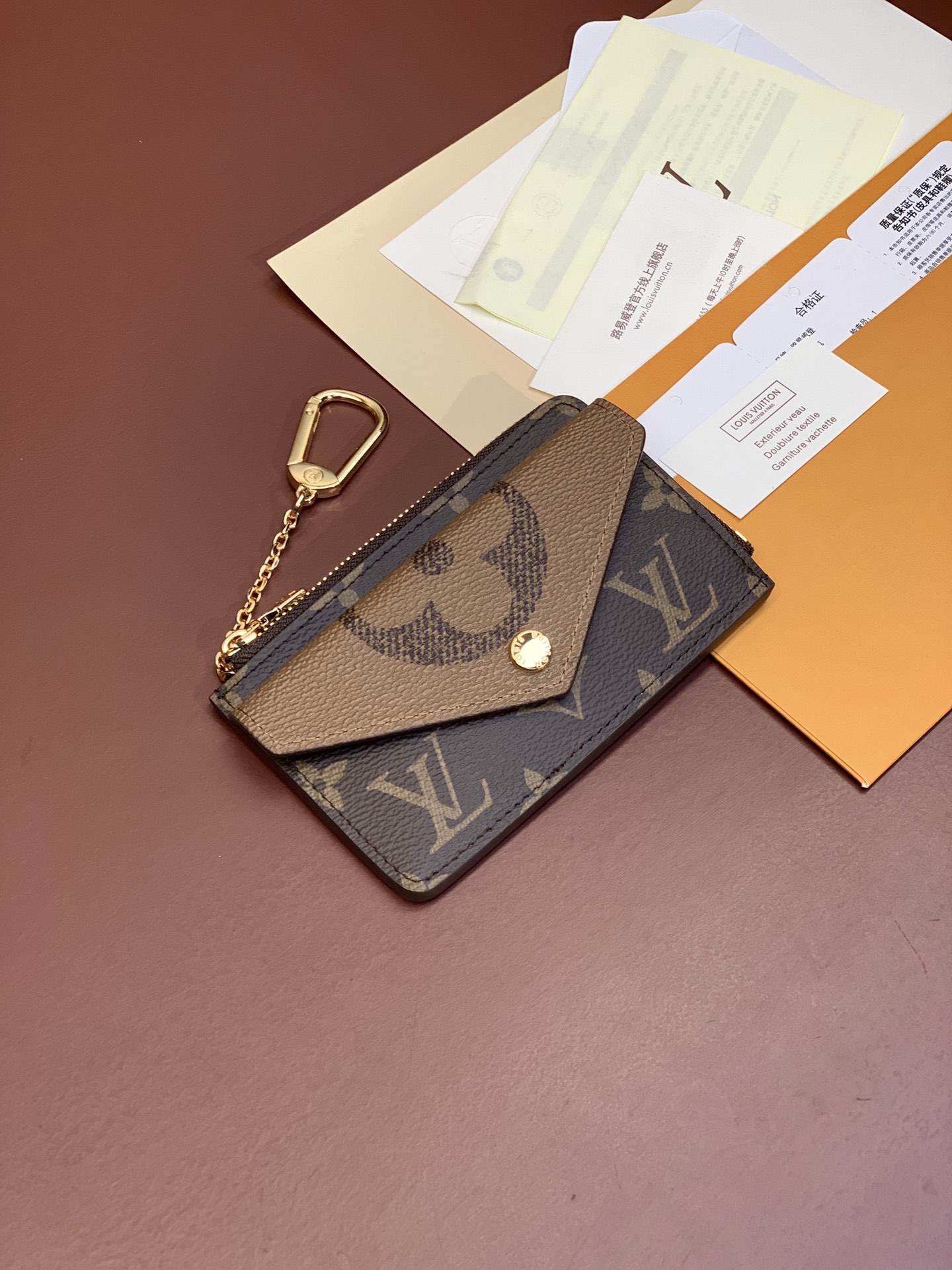 مشبك البطاقات Recto VERSO CARD CLIP مشبك بطاقات Recto Verso من قماش كلاسيكي من قماش Monogram مع حواف جلدية حادة وسحّاب عريض على شكل حرف L لفتح حجرة العملات المعدنية. جيب أمامي على شكل ظرف وجيب مركزي للأوراق النقدية المطوية وفتحة خلفية يمكن تثبيتها أيضًا في حقيبة اليد أو الحزام باستخدام قفل الخطاف والحلقة الحجم: 13.0 × 9.5 × 2.5380