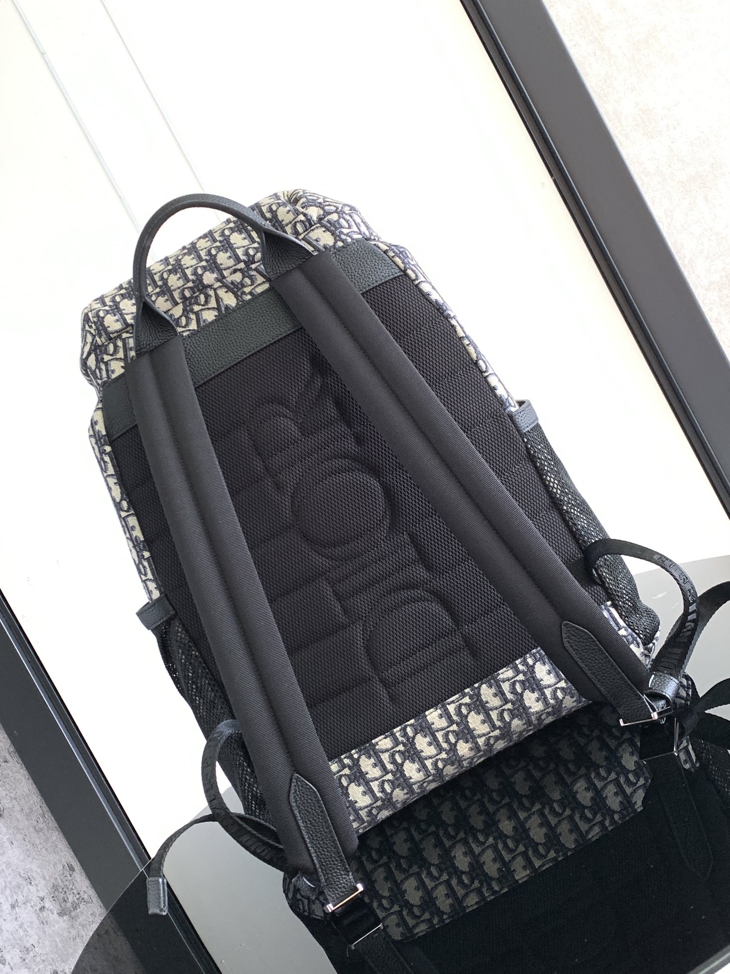 P 1220 Esta mochila Dior 8, novidade da coleção masculina verão 2014, homenageia o fabuloso ar livre e o estilo Dior com seu design de aba. Confeccionada em tecido estampado Oblique bege e preto, o compartimento principal tem uma aba com fecho Dior 8 para guardar os itens essenciais do dia a dia, um bolso frontal com zíper e bolsos laterais em tecido de malha para facilitar o acesso às suas chaves ou fones de ouvido, tornando-a prática para uma grande variedade de looks. Um complemento prático e versátil para qualquer lookEstampado oblíquo bege e pretoLogótipo Dior gravado em relevo no interiorAlça de ombro ajustável em tecido de malha acolchoadaPegas em peleMalha técnica acolchoada reforçada com o logótipo Dior no fundo da bolsaFecho de aba com 2 fivelas Dior 8Bolso frontal com fecho de correr2 bolsos laterais em tecido de rede na parte lateralBolso interior com fecho de correrSaco para o pó incluídoReference: 1EIBA187YKY_H27E1213Dimensões: 31 x 50 x 18 cm