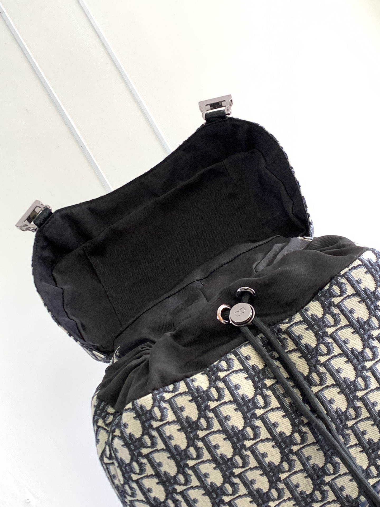 P 1220 Esta mochila Dior 8, novidade da coleção masculina verão 2014, homenageia o fabuloso ar livre e o estilo Dior com seu design de aba. Confeccionada em tecido estampado Oblique bege e preto, o compartimento principal tem uma aba com fecho Dior 8 para guardar os itens essenciais do dia a dia, um bolso frontal com zíper e bolsos laterais em tecido de malha para facilitar o acesso às suas chaves ou fones de ouvido, tornando-a prática para uma grande variedade de looks. Um complemento prático e versátil para qualquer lookEstampado oblíquo bege e pretoLogótipo Dior gravado em relevo no interiorAlça de ombro ajustável em tecido de malha acolchoadaPegas em peleMalha técnica acolchoada reforçada com o logótipo Dior no fundo da bolsaFecho de aba com 2 fivelas Dior 8Bolso frontal com fecho de correr2 bolsos laterais em tecido de rede na parte lateralBolso interior com fecho de correrSaco para o pó incluídoReference: 1EIBA187YKY_H27E1213Dimensões: 31 x 50 x 18 cm