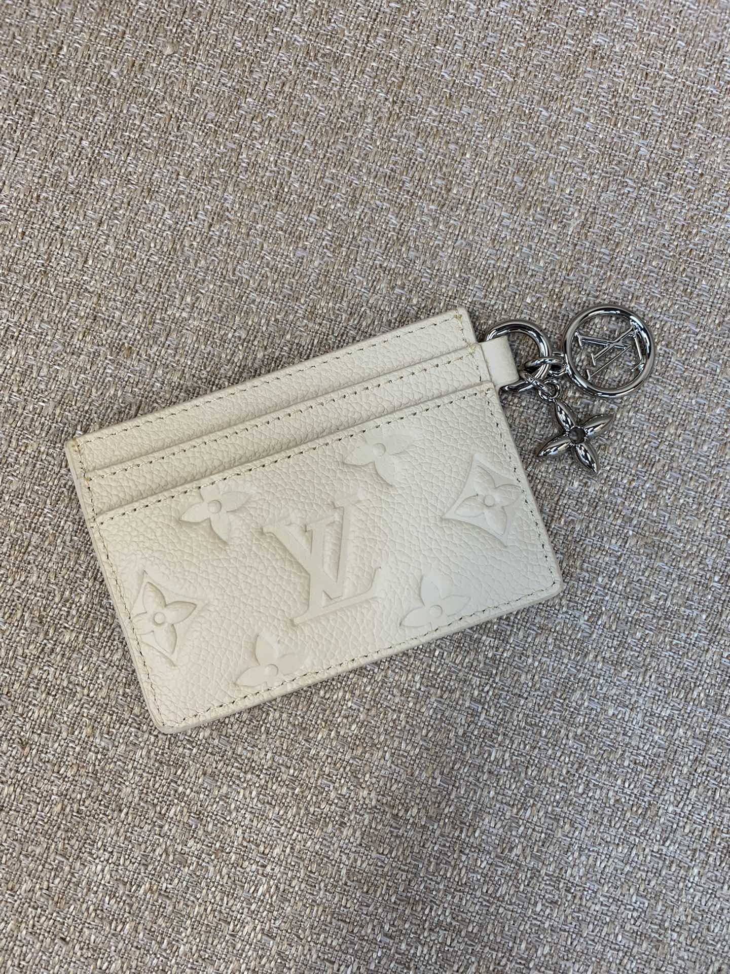 M12178 Beige Ce porte-cartes L*Charms est sublimé par un effet de brillance Idéal pour les fêtes de fin d'année Issu de la collection L*Ski, ce modèle iconique en cuir Monogram Empreinte présente des breloques florales L*Circle et Monogram incrustées de cristaux Cet élégant accessoire dispose de deux fentes extérieures de chaque côté de la pièce et d'une fente plus large au centre. Taille des compartiments : 10x7x0,3cm - manufacture haute couture