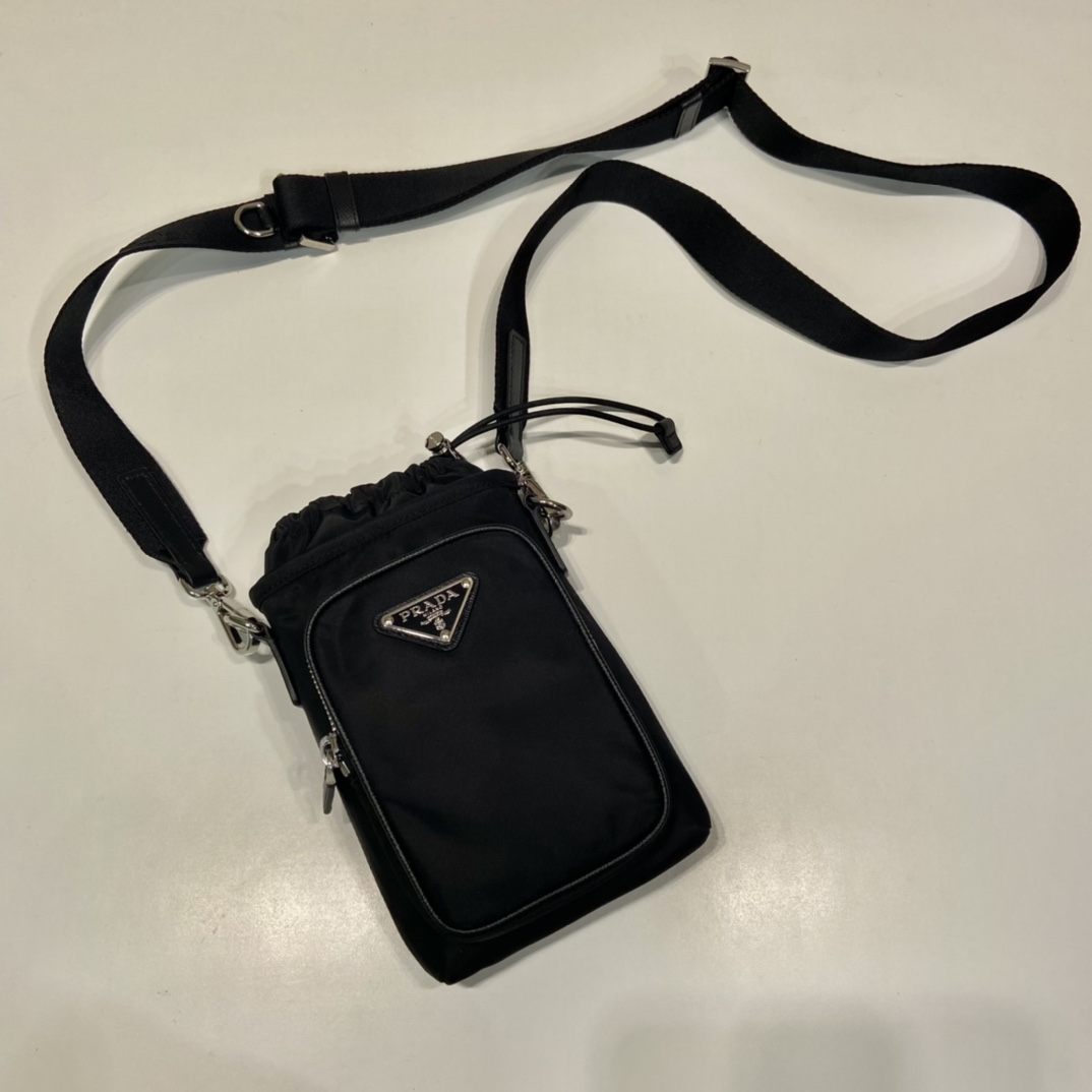 P600 Bolsa maletín para teléfono 2ZH155Esta bolsa para teléfono está fabricada con el innovador nylon reciclado Re-Nylon para un aspecto moderno y urbanoCorrea ajustable de nylon para el hombro y cierre de cordón para un aspecto chicLogotipo frontal y bolsillos delanteros para un aspecto fresco y eleganteLongitud 13 x Altura 18cm👏👏👏👏👏👏👏👏👏👏