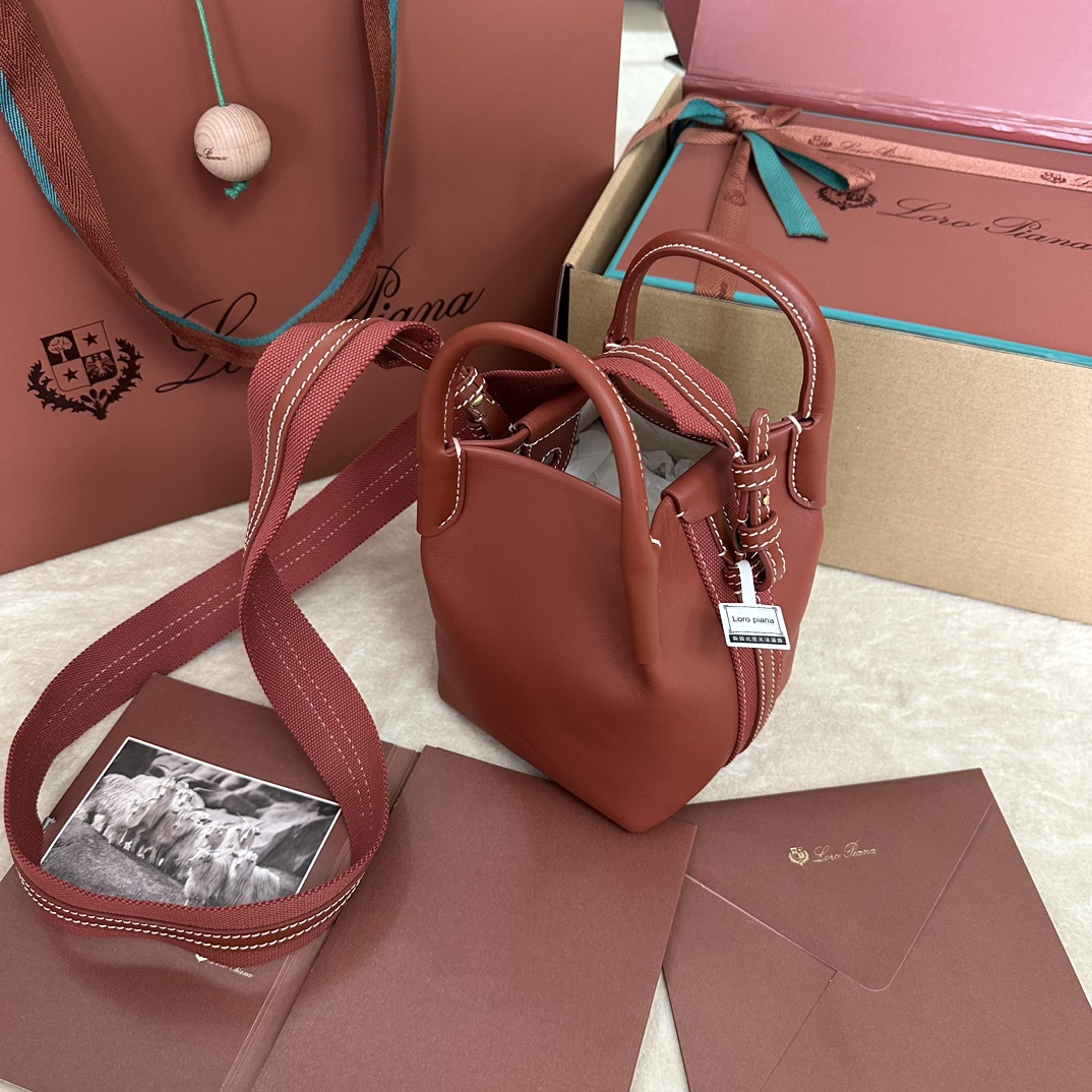 🐠Loro piana Small Bucket Bale Mini Handbagカラー：マーブルピンクBaleバッグの控えめなエレガンスと記念碑的なスタイルは、Loro pianaの独特な伝統をまたひとつ証明しています。四角いフォルムと、カシミヤを重ねるための大きな束に由来する名前は、ロロ・ピアーナの上質なクラフトマンシップへのこだわりを表しています。ボディは非常にソフトなナチュラルグレインのカーフレザー製。サイズ：長さ16✖️14✖️23CM-ハイファッションファクトリー