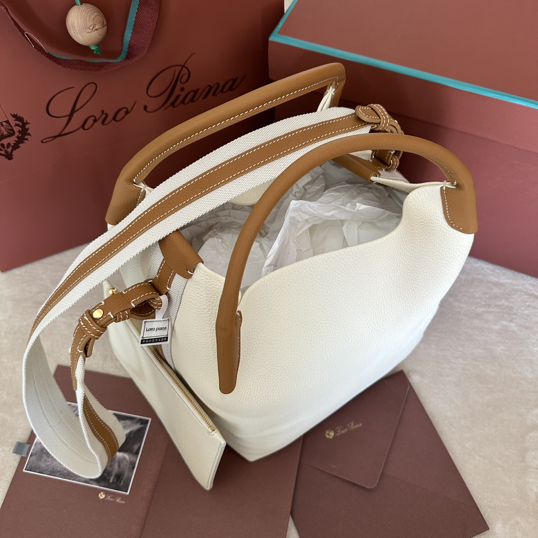 💰1920Bolso grande Big Bucket Bale de Loro pianaColor: Blanco con marrónEl bolso Bale es un testimonio de la herencia distintiva de Loro piana, con su elegancia despreocupada y su estilo atemporal. Su forma cuadrada y su nombre, derivado de los grandes fardos utilizados para guardar la cachemira, representan el compromiso de Loro piana con la artesanía. El cuerpo es de piel de becerro con un grano natural muy suave. Talla: largo 28✖️22✖️36CM-fábrica de alta costura