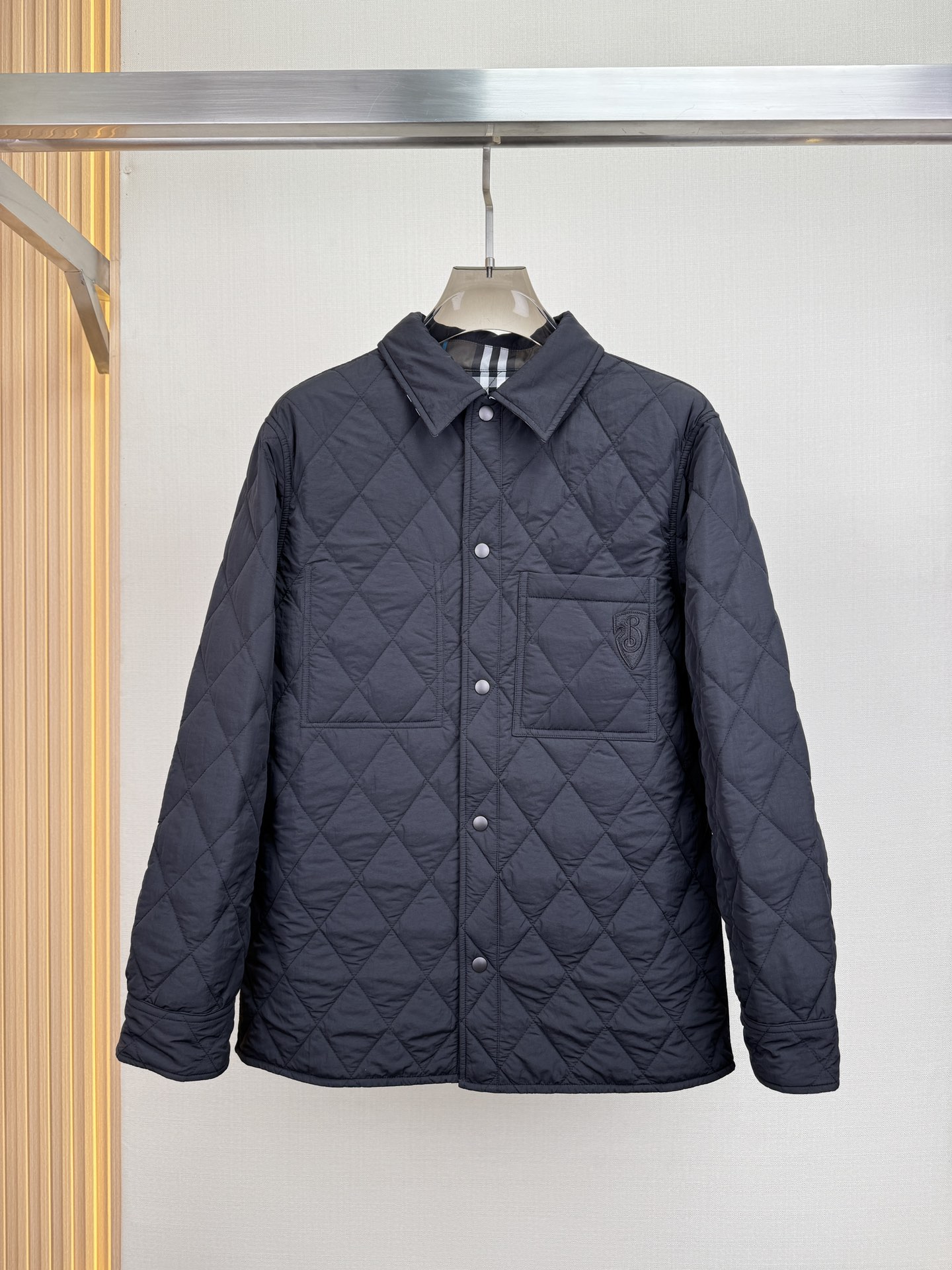 p960 BURBERRY Quilted jacket shirtCotton jacket in Burberry's latest grey and blue check patternDouble wear designIn solid nylon on one side and Burberry's latest grey and blue check cotton twill on the other for a casual fitAppliquéd with a B-shield motifFrom the Burberry Classics collection, Burberry's classic collection is a distinctive interpretation of style and sophisticationQuilted cotton is designed to keep you warm and cozy, without the bulk. A closet must-have!Details: Snap button closureChest patch pocketButtoned cuff pockets with B shield appliquésColor: Black with gray and blue check patternSize: M-3XL (48-56)