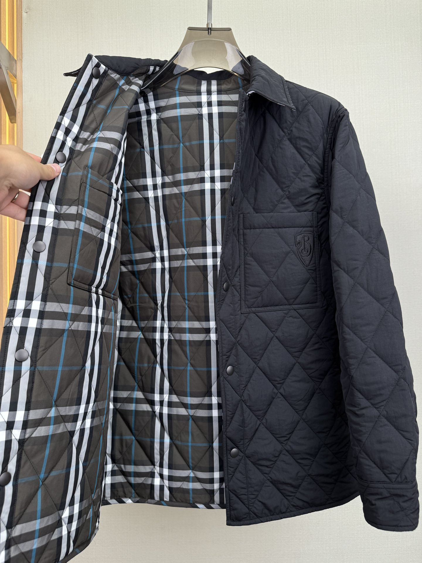 p960 BURBERRY Quilted jacket shirtCotton jacket in Burberry's latest grey and blue check patternDouble wear designIn solid nylon on one side and Burberry's latest grey and blue check cotton twill on the other for a casual fitAppliquéd with a B-shield motifFrom the Burberry Classics collection, Burberry's classic collection is a distinctive interpretation of style and sophisticationQuilted cotton is designed to keep you warm and cozy, without the bulk. A closet must-have!Details: Snap button closureChest patch pocketButtoned cuff pockets with B shield appliquésColor: Black with gray and blue check patternSize: M-3XL (48-56)