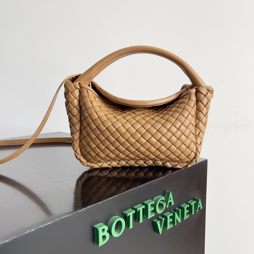 BOTTEGA VENETA迷你COBBLE元宝包 本季mini Cobble系列带来了手提包这一全式包身酷似“元宝”形状给你整个秋冬的好运加持!这款元宝包由三块夹棉打造而成包身一体无衬里彰显安静的力量手袋经过精心设计打造出立体感连接处及边缘通过小羊皮皮条的润饰打造简约感手袋不另设内衬可直接欣赏到表里如一的小羊皮内外皆美这款手提包顶部的手柄由皮革包裹的绳索打造相当结实可拆卸的肩带由手袋内的皮革环扣固定可手提肩背或斜挎超好搭配!
款号：805739
尺寸：23*11*8cm-高仿包包