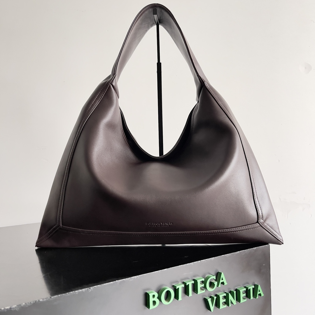 Bottega Veneta这个2024秋冬的主打 从秀场到街头都在大放异彩它不仅带来浓厚的复古气息还能通过多种搭配方式轻松演绎出不同风格的造型无论是干练优雅的职场造型还是休闲舒适的日常穿搭全进口小牛皮都是你不容错过的时尚元素!
款号：803977
尺寸：41*20*8cm-高仿包包