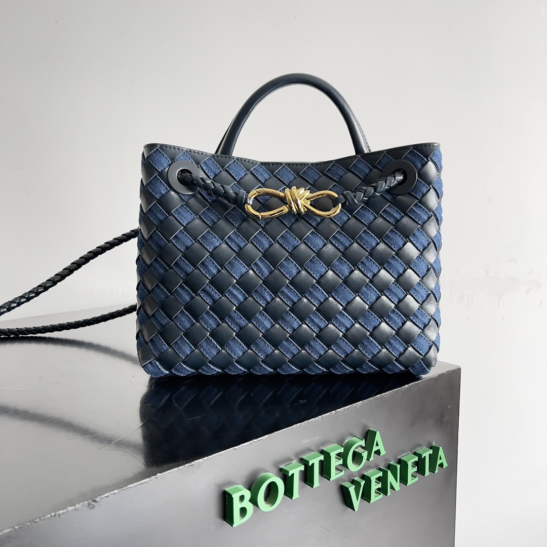 BOTTEGA VENETAANDIAMO手提包  这款牛仔布编织包将复古与新潮完美交织!手工编织的牛仔布每一缕都承载匠心拼色设计跳脱常规不仅容量感人更添一份趣味与可爱轻松Hold住各种风格精致金属配件闪耀在牛仔的粗犷之上硬朗与柔美并存牛仔自带年轻活力的属性给人既复古经典又松弛自由的感觉这款包在编制过程中手工将牛仔布通过细小的缝隙编入皮面中技艺相当精湛!容量更不用说雨伞水杯都能放得下!
款号：743568
尺寸：25*22*10.5cm-高仿包包