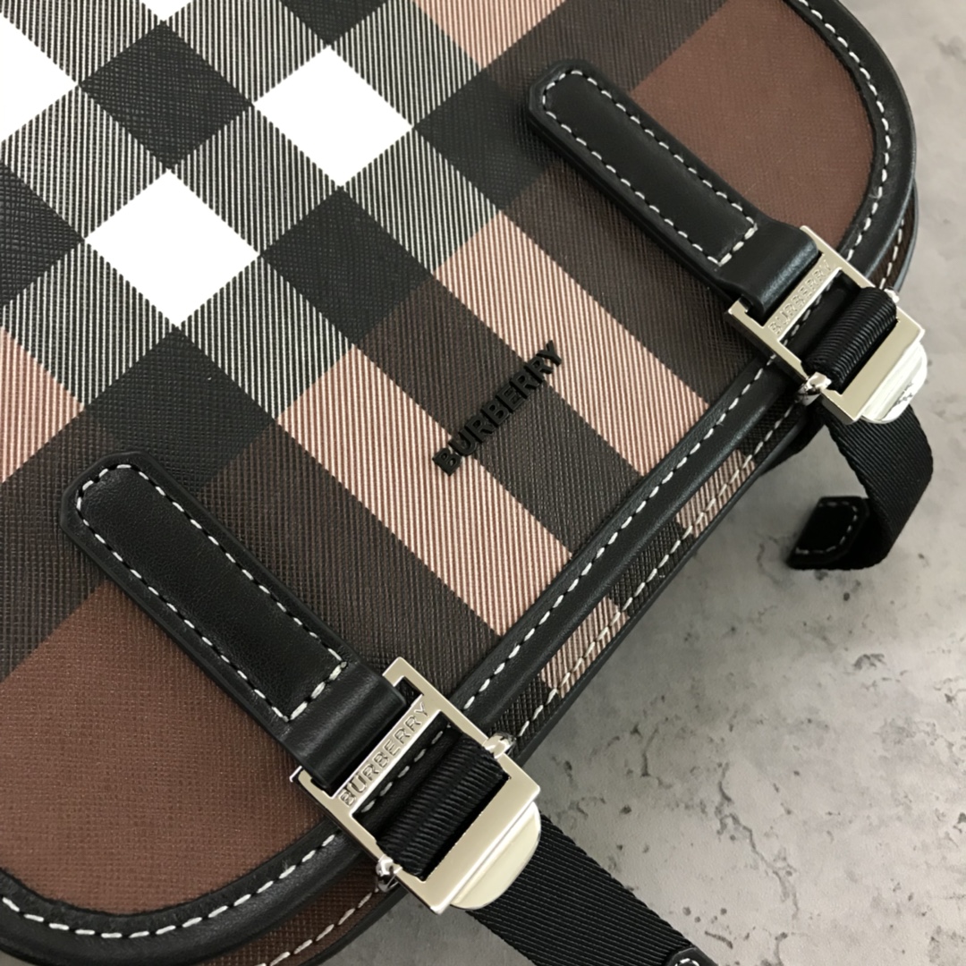 Burberry's sleek messenger bag is updated in checkered eco-canvas, which is made from renewable resources and requires less water and generates less carbon dioxide than traditional coated canvas. The bag is printed with a logo and trimmed with a striped leather trim and an adjustable shoulder strap. 1 external pocket with hidden magnetic closure; 1 internal zipped pocket; 1 internal slit pocket. Fold-over front flap with snap and buckle closure. Hand-painted edges. Shiny metal hardware. Burberry monogrammed logo on front.22x19x7 p900