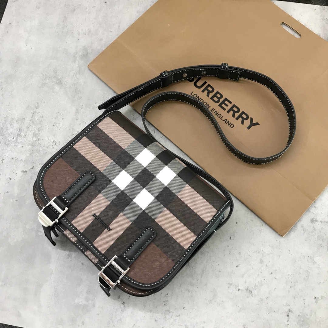 Burberry's sleek messenger bag is updated in checkered eco-canvas, which is made from renewable resources and requires less water and generates less carbon dioxide than traditional coated canvas. The bag is printed with a logo and trimmed with a striped leather trim and an adjustable shoulder strap. 1 external pocket with hidden magnetic closure; 1 internal zipped pocket; 1 internal slit pocket. Fold-over front flap with snap and buckle closure. Hand-painted edges. Shiny metal hardware. Burberry monogrammed logo on front.22x19x7 p900