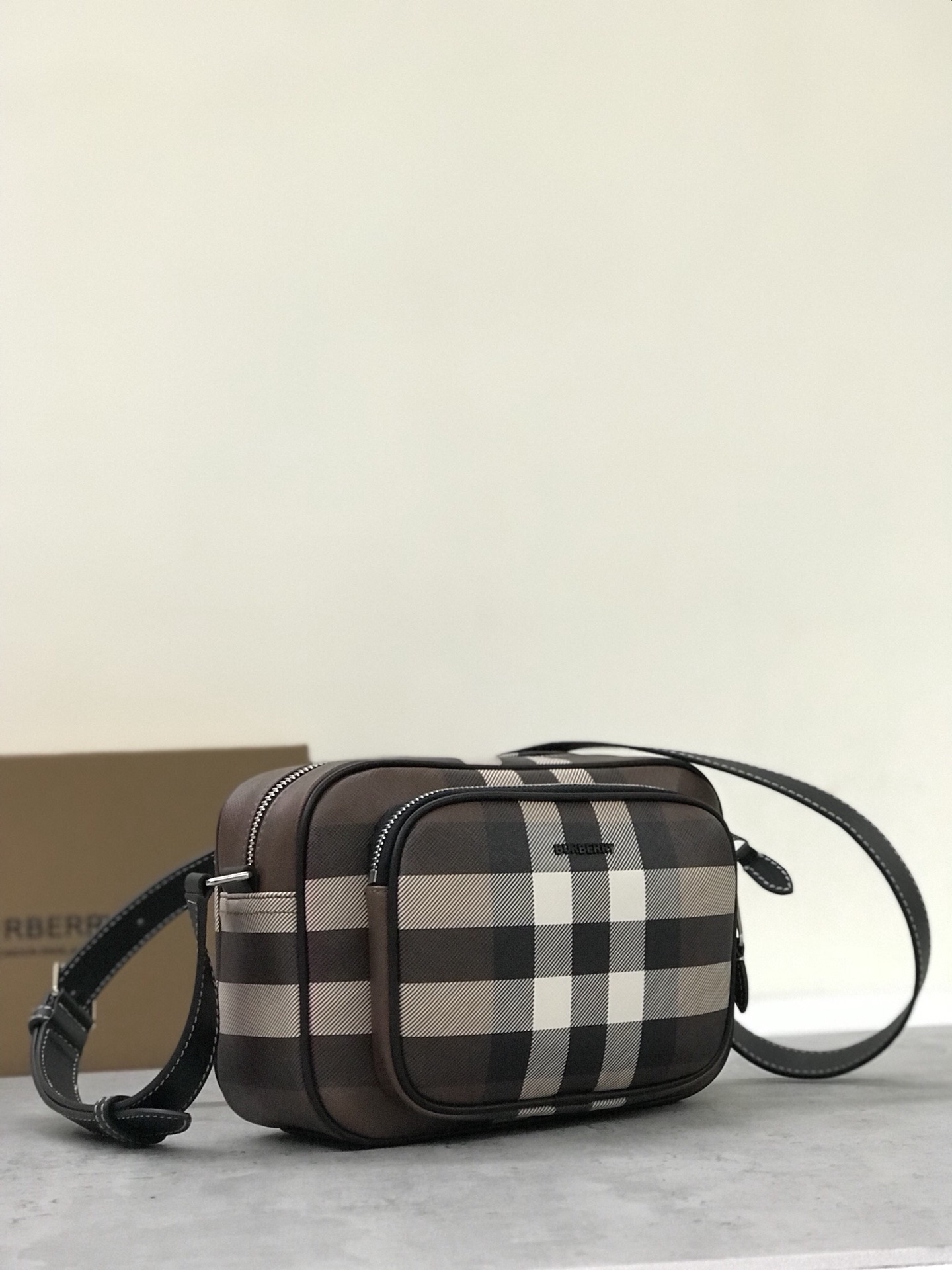 Burberry's compact camera bag is refreshed with a checkered eco-canvas that's made primarily from renewable resources and requires less water and generates less carbon dioxide than traditionally coated canvas or with an adjustable, welded leather strap for crossbody use.22.5 x 8.2 x 14.5cm.Adjustable slanting straps.3 card slots.1 zippered exterior pocket.1 external welt pocket.1 zippered closure. Zipper closure. Hand-painted edges. Shiny metal hardware. Burberry logo p860 on front.