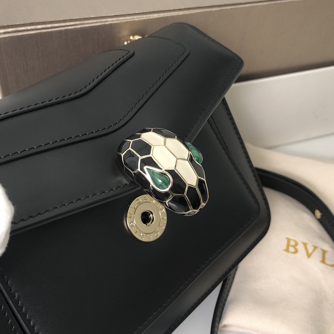 Le nouveau sac cross-body "SERPENTI FOREVER" est une déclaration de style urbain. Le sac est en cuir de veau noir avec des accessoires en laiton plaqué or clair en onyx noir et blanc, en émail et en malachite verte. Les yeux sensuels du sac sont ornés d'un fermoir classique en forme de tête de serpent. La chaîne en serpent réglable et la bandoulière en cuir permettent de l'accessoiriser facilement avec des tenues de jour élégantes. smallSizeDeux compartiments de rangement et un petit miroir de maquillageUn porte-cartes de crédit inamovibleUne poche ouverteUne poche zippée et deux poches extérieures19 X 13 X 7 cm. -Haute réplique des sacs