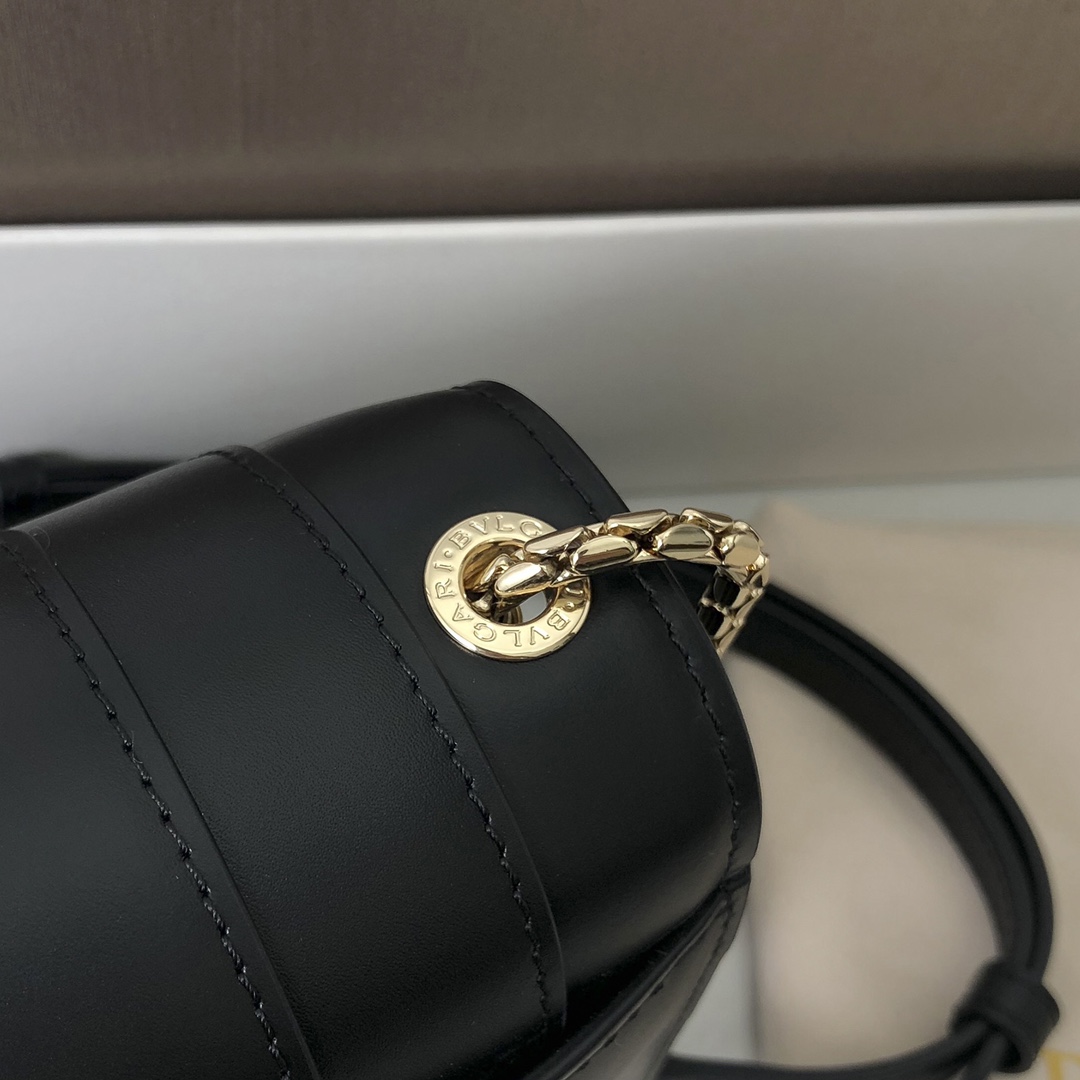 Le nouveau sac cross-body "SERPENTI FOREVER" est une déclaration de style urbain. Le sac est en cuir de veau noir avec des accessoires en laiton plaqué or clair en onyx noir et blanc, en émail et en malachite verte. Les yeux sensuels du sac sont ornés d'un fermoir classique en forme de tête de serpent. La chaîne en serpent réglable et la bandoulière en cuir permettent de l'accessoiriser facilement avec des tenues de jour élégantes. smallSizeDeux compartiments de rangement et un petit miroir de maquillageUn porte-cartes de crédit inamovibleUne poche ouverteUne poche zippée et deux poches extérieures19 X 13 X 7 cm. -Haute réplique des sacs