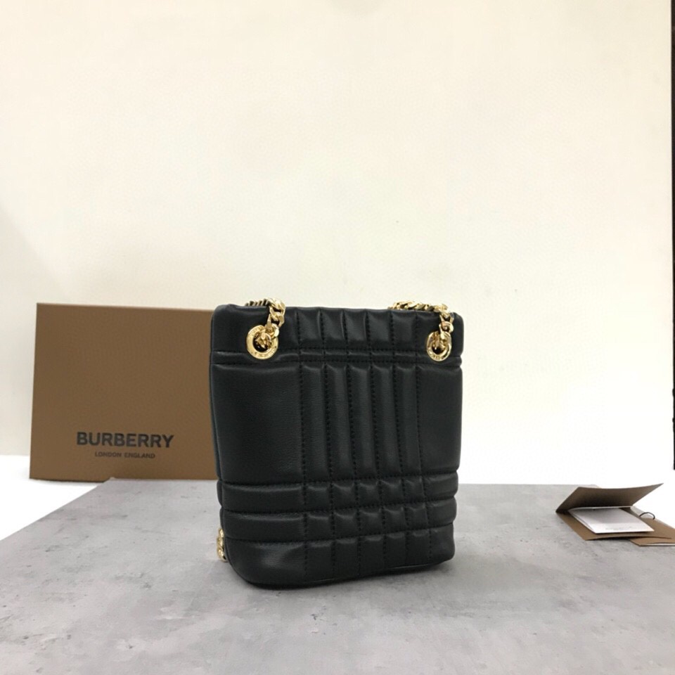 Le sac Lola - Lorna de Burberry est un sac matelassé chic et extrêmement doux, fabriqué en Italie à partir de peau d'agneau tannée et décoré du logo exclusif de Thomas Burberry et d'une bandoulière en chaîne brillante qui peut être portée à l'épaule ou en bandoulière. Modèle : Mini sac Bucket Dimensions : 20 x 9 x 16 cm p900