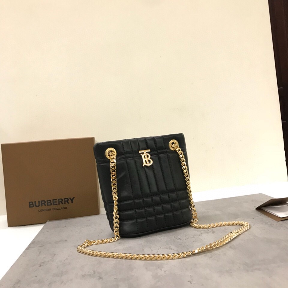 Le sac Lola - Lorna de Burberry est un sac matelassé chic et extrêmement doux, fabriqué en Italie à partir de peau d'agneau tannée et décoré du logo exclusif de Thomas Burberry et d'une bandoulière en chaîne brillante qui peut être portée à l'épaule ou en bandoulière. Modèle : Mini sac Bucket Dimensions : 20 x 9 x 16 cm p900