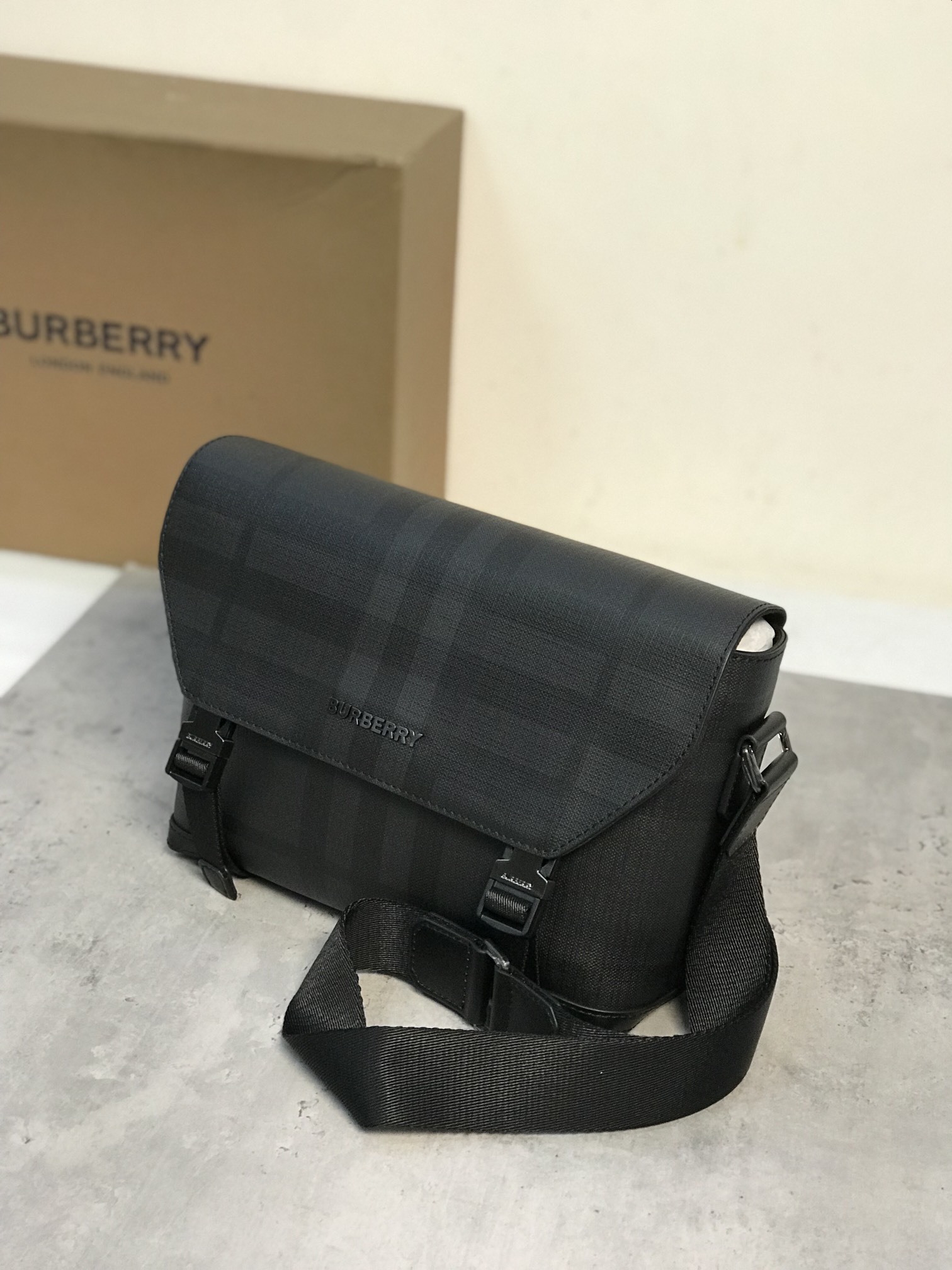 Burberry small fitEmbalagem de mensageiro robusta com marca de pontosDesign em xadrez cinzento-carvão com acabamentos em pele lisa e design do logótipoPossui um bolso com fecho para guardar artigos pequenosAlça de ombro ajustável para um design práticoPelo menos 30% dos principais materiais utilizados nesta peça são derivados de materiais de base biológicaMateriais de base biológica são derivados de recursos naturais renováveis, como plantas e óleo de rícino29 x 8,5 x Alça de ombro ajustável de 17,5 cm.1 bolso exterior com fecho; 1 bolso interior com fecho. Aba dobrável com fecho de fivela. Bordos pintados à mão. Ferragens em metal brilhante. Logótipo Burberry p1000 na frente.