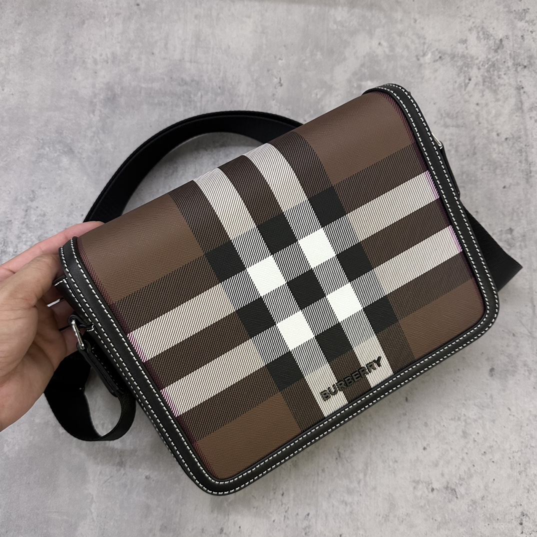 Burberry messenger bagSophisticated stand-up designDecorated with Burberry check pattern with leather trim and brand logo25.5 x 6.5 x 21.5cm.Adjustable shoulder strap.1 external slip pocket; 1 internal slip pocket. Top flap with magnetic closure. Hand-painted edges. Burberry logo p1000 on front.