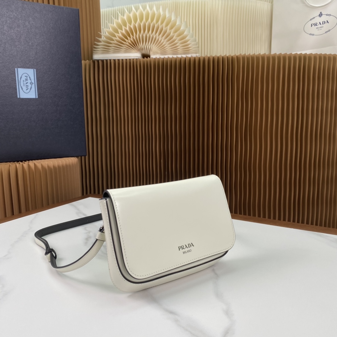 P1100 Prada Bolso para teléfono de piel brillante blanca 2VD061¡Súper versátil y de buen aspecto chic hipster debe comprarlo! Inspirado en la colección CleLa exclusiva estructura lateral en ángulo conforma una silueta minimalistaLa solapa está adornada con un logotipo estampado en calienteEl bolso en general es minimalista a la par que eleganteEl interior cuenta con un pequeño bolsillo de parcheTamaño:18*12,5*2,5cm-Bolso de alta calidad