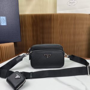 P1340 Prada Negro 2VH170 Este bolso bandolera está confeccionado en piel saffiano con líneas minimalistas para un look llamativo. La icónica piel saffiano es sinónimo de lujo y un símbolo de estatus de la artesanía tradicional italiana del cuero. Viene con una bolsa de piel extraíble y etiquetas triangulares esmaltadas y una correa larga de nylon extraíble y ajustable para el hombro. Dimensiones: L20xH13.5xB7cm