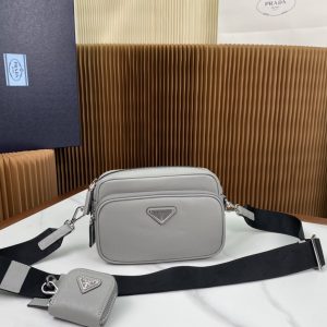 P1340 Prada Blanco 2VH170 Este bolso bandolera está confeccionado en piel saffiano con líneas minimalistas para un look llamativo. La icónica piel saffiano es sinónimo de lujo y un símbolo de estatus de la artesanía tradicional italiana del cuero. Viene con una bolsa de piel extraíble y etiquetas triangulares esmaltadas y una correa larga de nylon extraíble y ajustable para el hombro. Dimensiones: L20xH13.5xB7cm