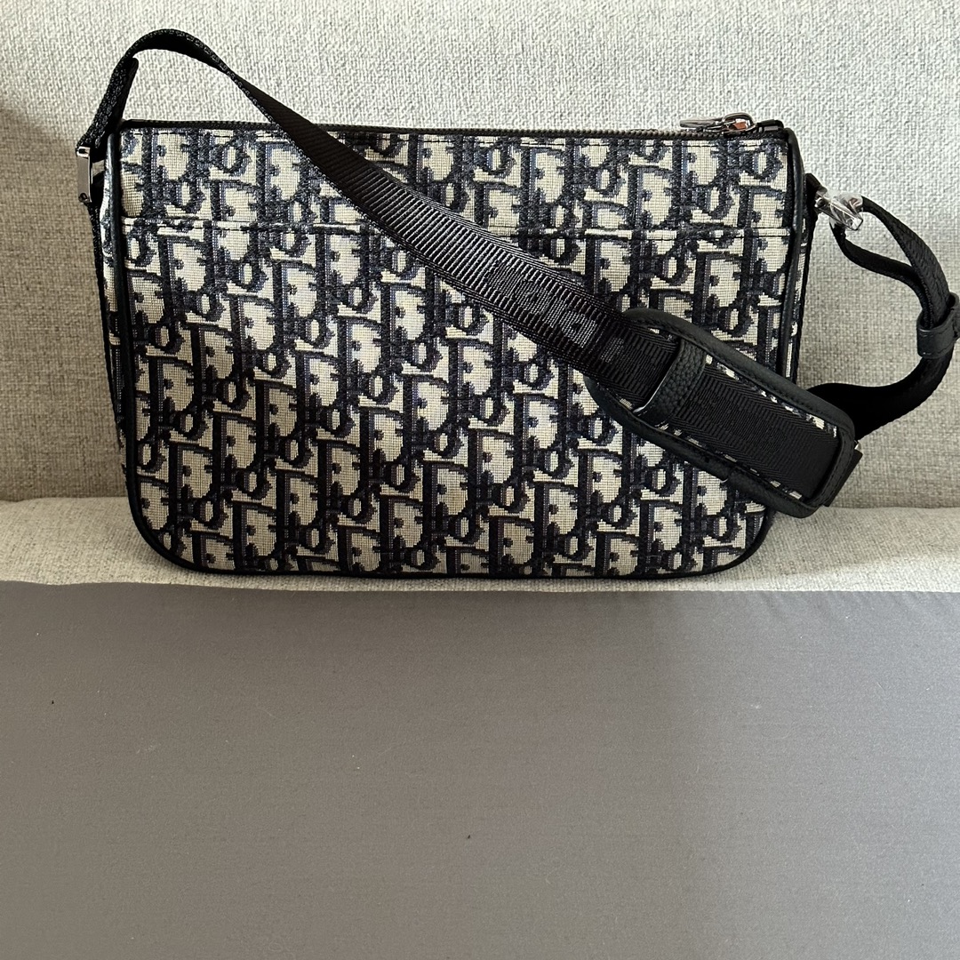 El bolso Dior 8 con bandolera es un diseño distintivo de la colección masculina Primavera 2014, con un glamour moderno y una estética minimalista, confeccionado en tejido estampado Oblique beige y negro. Su robusta estructura se completa con compartimentos con cremallera para guardar los objetos de uso diario, y la solapa delantera está decorada con una hebilla Dior 8 con un bolsillo textil de malla y una bandolera ajustable con el logotipo Christian Dior. o bandoleraNúmero de modelo 6018Talla 26-18-5Estampado oblicuo beige y negro con logotipo Dior en relieve en el interiorCierre con cremallera y hebilla Dior 8Bandolera ajustable de nailon jacquard con logotipo Christian Dior Compartimento superior con cremalleraBolsillo delantero de tejido de mallaBolsillo trasero de parche con bolsa guardapolvoFabricado en Italia191701000